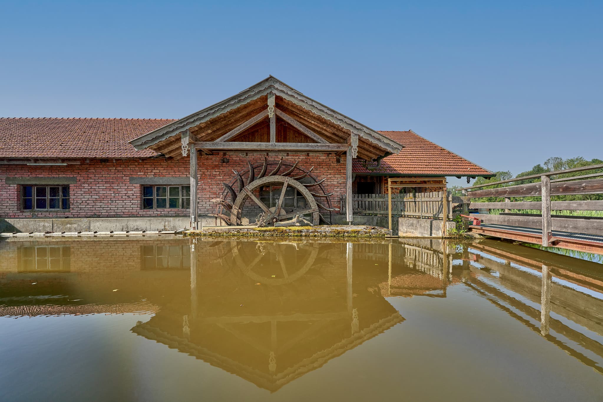 Historisches Wasserrad der Maumühle in Erharting im Landkreis Mühldorf am Inn, Oberbayern, Region Inn-Salzach, Deutschland. Ein idyllisches Industriedenkmal.