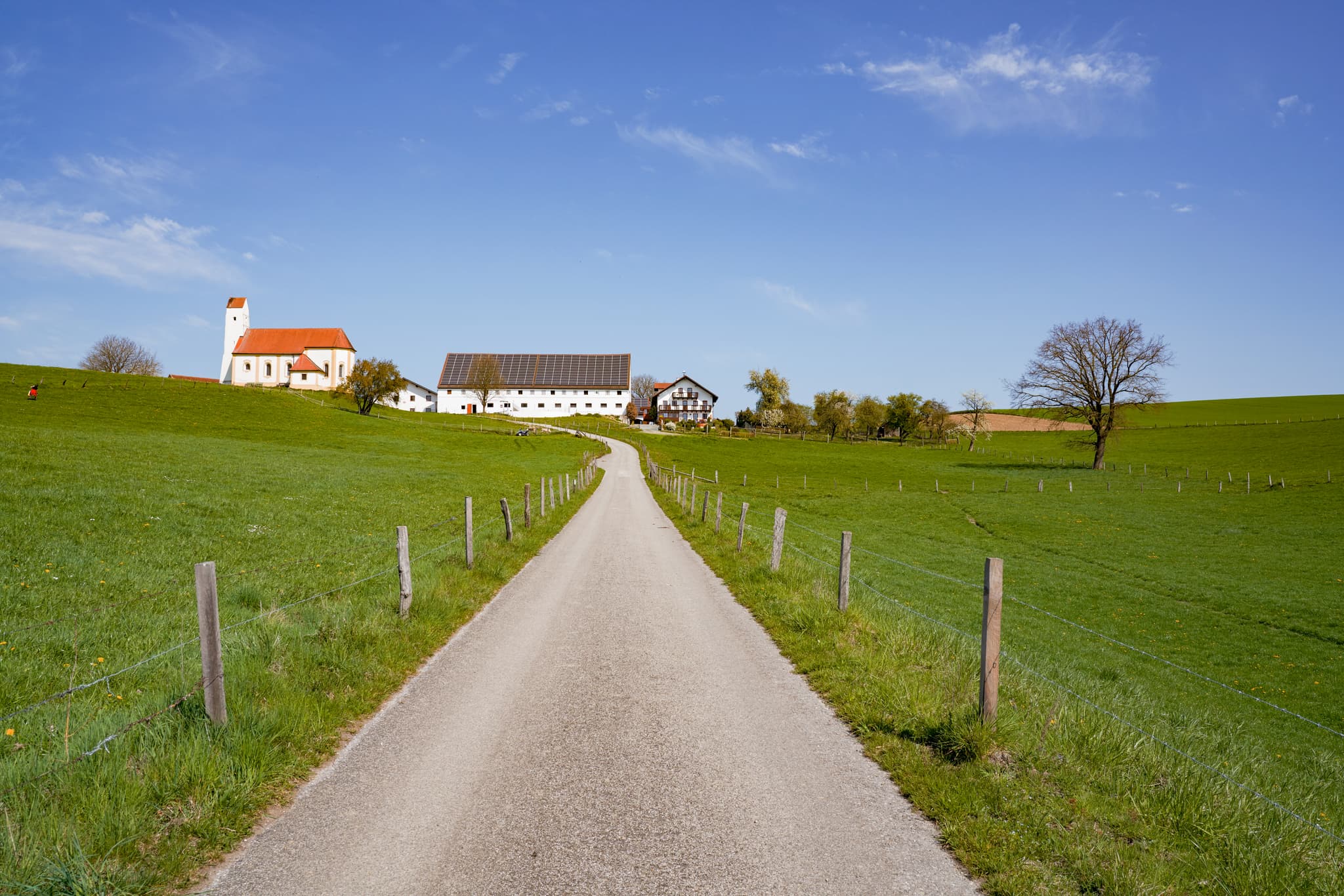 Idyllische Kirche Sankt Pankratius in Mettenheim, Mühldorf am Inn, Oberbayern, Region Inn-Salzach, Deutschland. Landschaftsbild mit Feldweg und Weitblick.