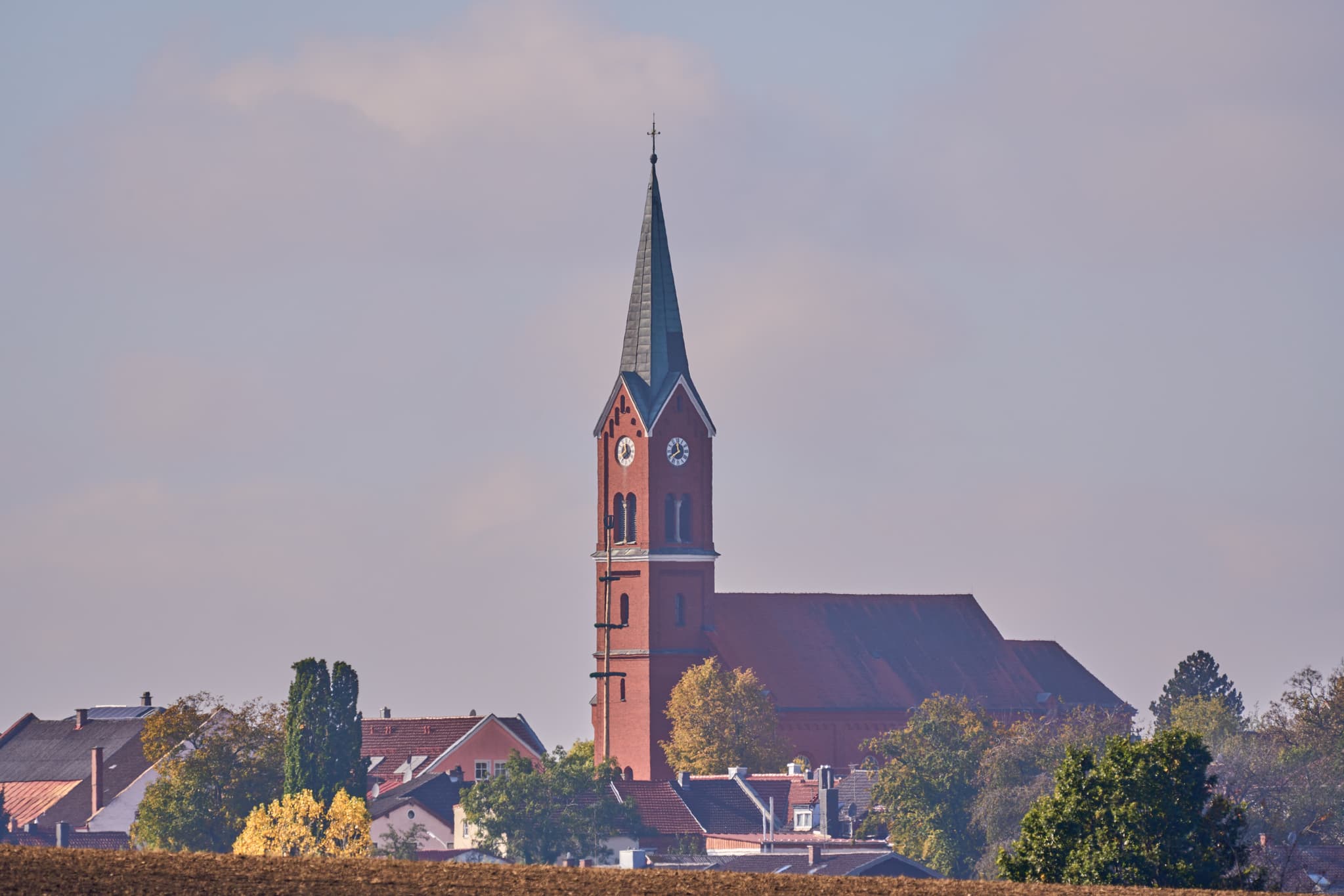 Ländliche Ortsansicht von Wurmannsquick, Rottal-Inn, Niederbayern, Deutschland. Zeigt die Pfarrkirche St. Andreas und Häuser mit Feldern im Holzland.