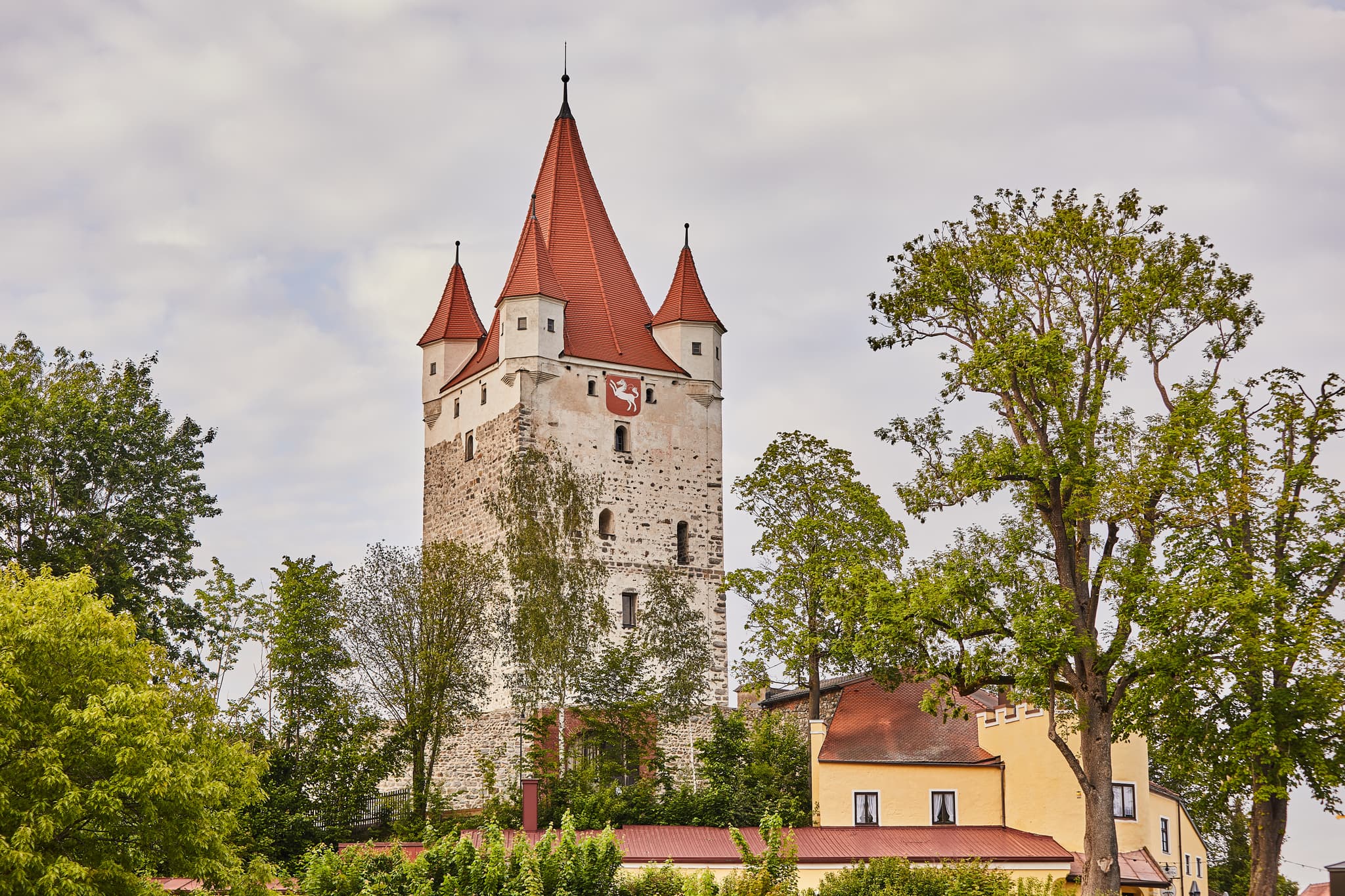 Markanter Schlossturm, Teil der historischen Burganlage in Haag, Mühldorf am Inn. Bauwerk in Oberbayern, Inn-Salzach, Deutschland. Umgeben von Bäumen.