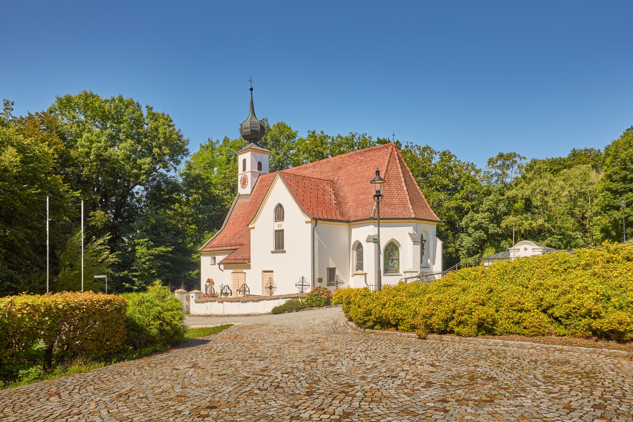Pfarrkirche Radegundis in Hadermarkt, St. Radegund, Braunau am Inn, Oberösterreich, Innviertel, Österreich. Kirchengebäude in grüner Landschaft.