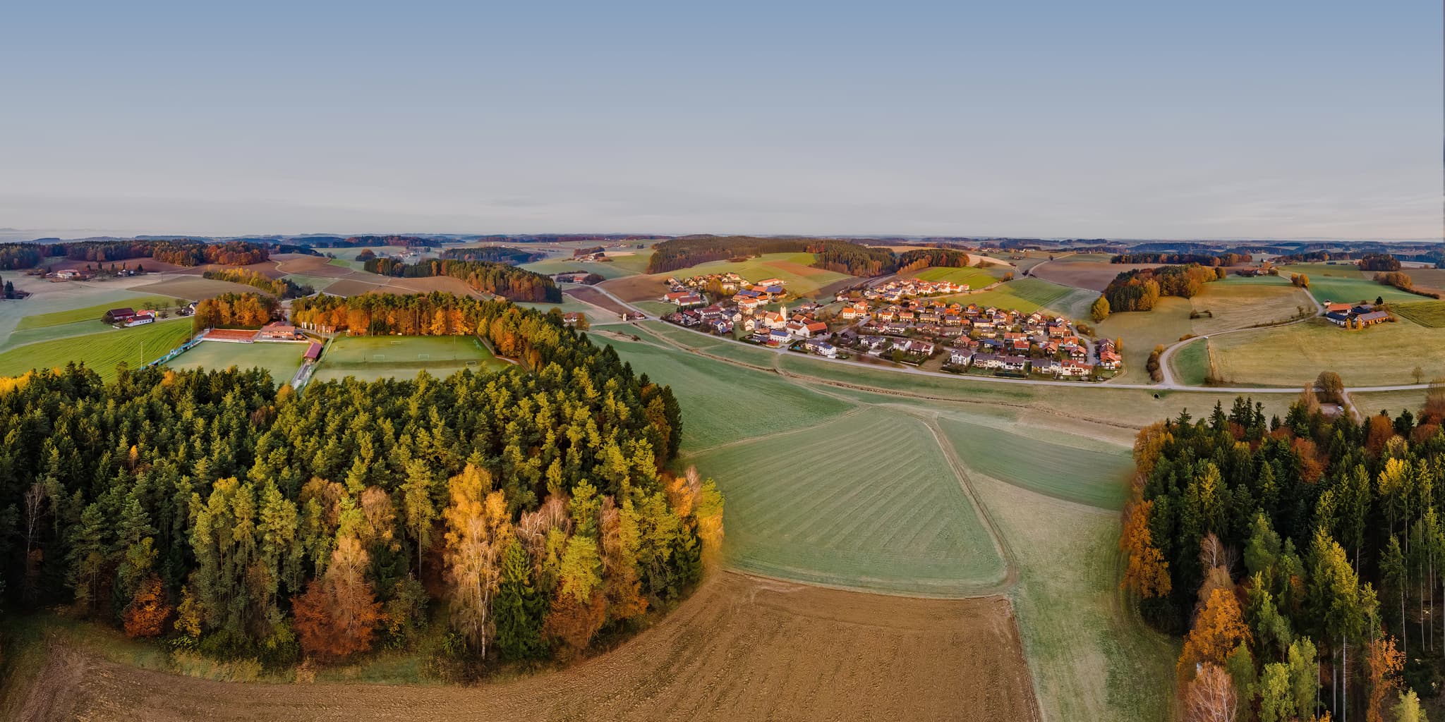 Luftaufnahme des Sportplatzes und der umliegenden Landschaft bei Erlbach im Landkreis Altötting, Oberbayern, Region Inn-Salzach zeigt Felder und Wälder.