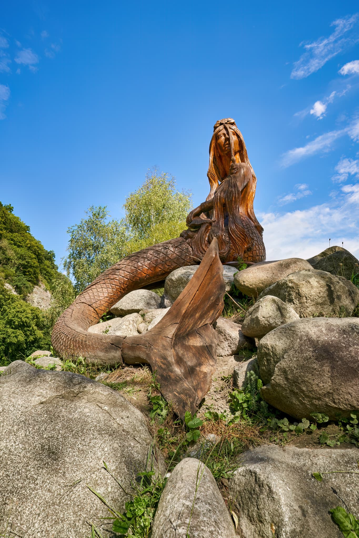 Holzskulptur einer Nixe (Isa) am Donauradweg in Thyrnau, Landkreis Passau, Niederbayern, Deutschland. Ein schöner Rastplatz, direkt an der Donau gelegen.