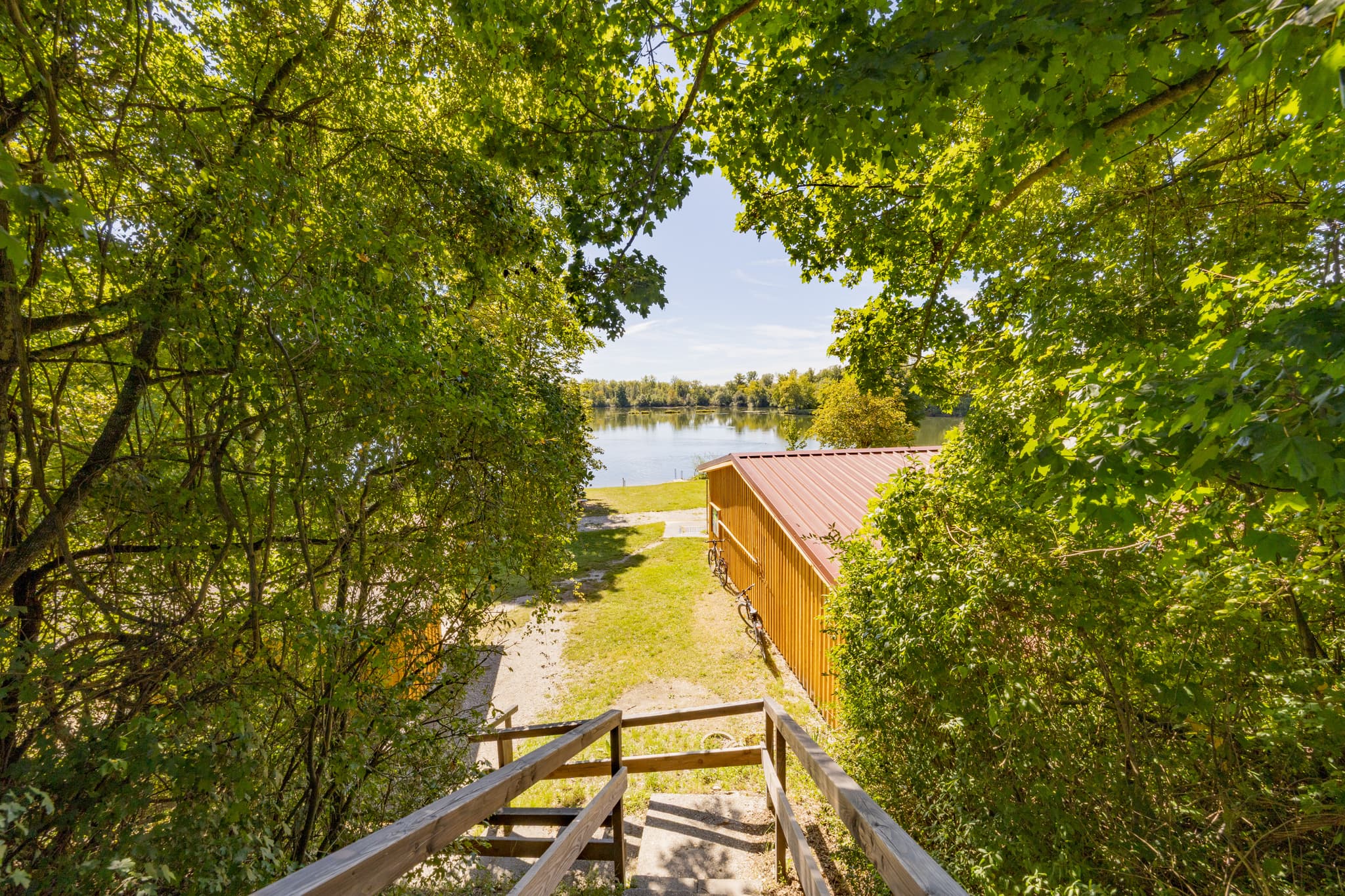 Waldsee Lago Sommer in Kirchdorf am Inn, Rottal-Inn, Niederbayern, Deutschland. Der Badesee Simbach im Bäderdreieck zeigt grüne Ufer unter blauem Himmel.