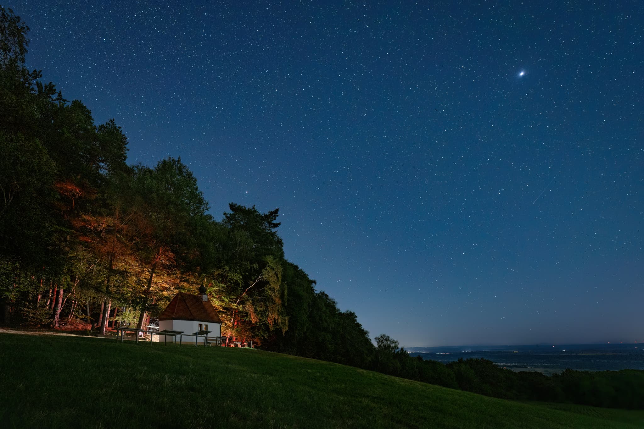 Nachtaufnahme der Bertenöder Kapelle bei Stubenberg im Landkreis Rottal-Inn, Niederbayern. Sternenhimmel im Holzland / Bäderdrieck, Bayern, Deutschland.
