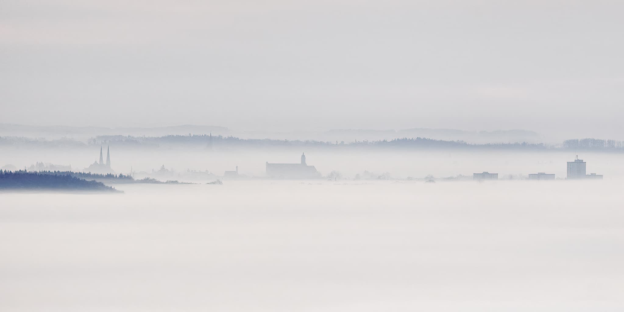 Gassen, Marktl am Inn im Landkreis Altötting, Oberbayern, Deutschland. Die Inn-Salzach-Region ist in Nebel gehüllt, nur Teile von Altötting ragen heraus.