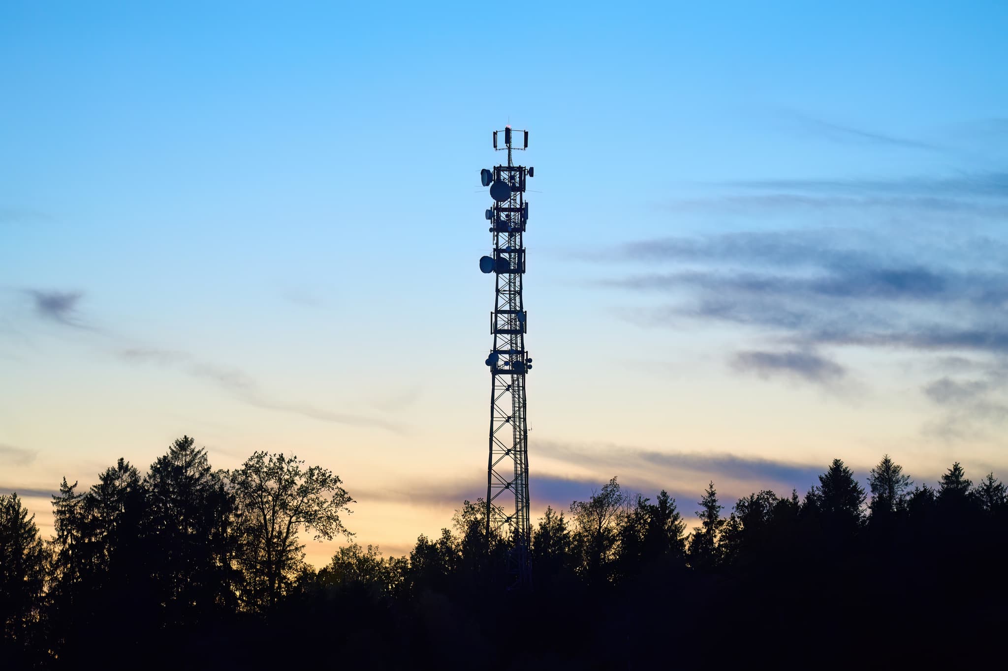 Funkturm im Abendhimmel in Rottenstuben, Hebertsfelden, Rottal-Inn, Niederbayern. Silhouette von Turm und Bäumen prägen die Landschaft im Holzland, Deutschland.