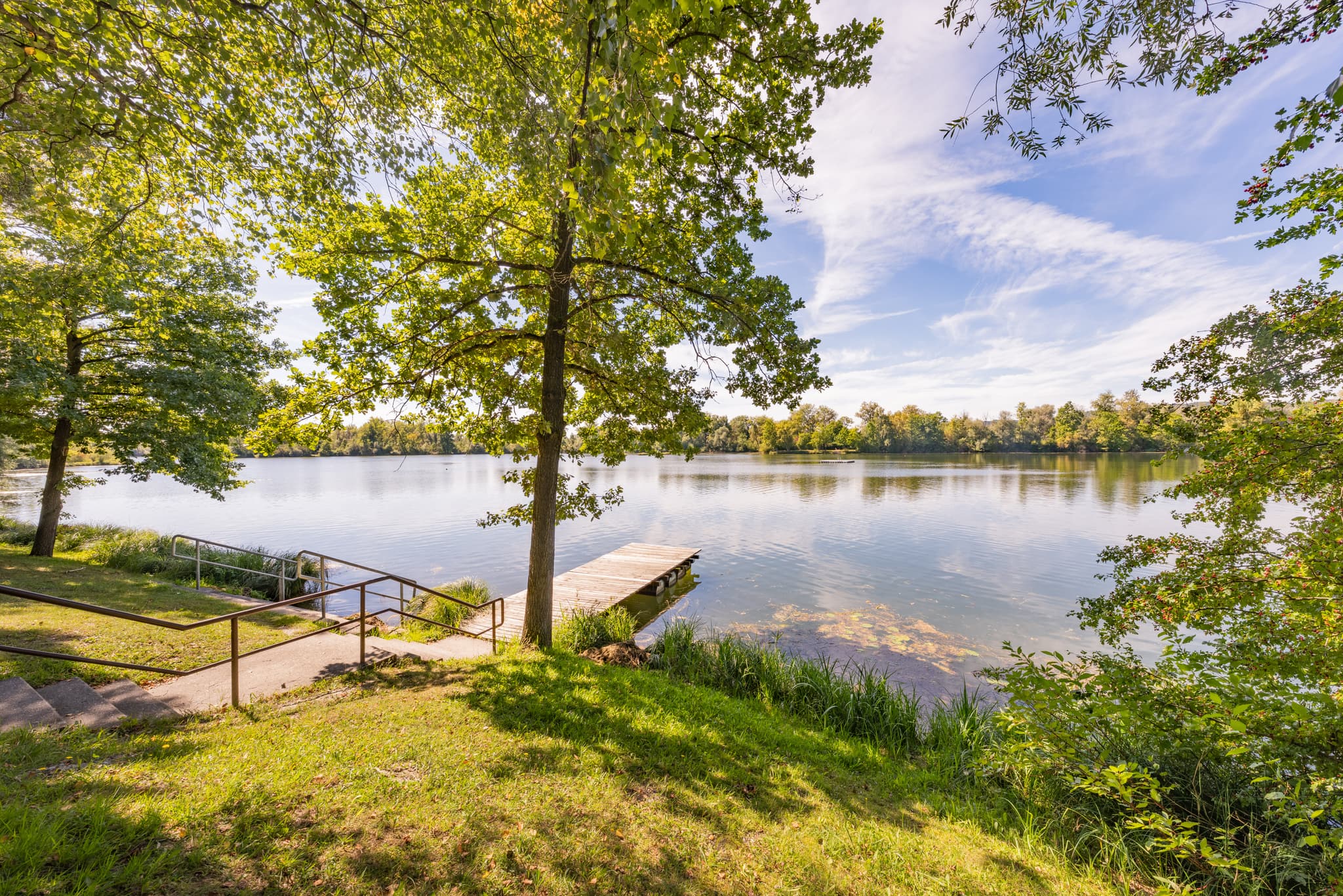 Waldsee mit Badesteg und grüner Uferlandschaft am Waldsee Lago Sommer in Kirchdorf am Inn, Landkreis Rottal-Inn, Niederbayern, Region Bäderdreieck, Deutschland.