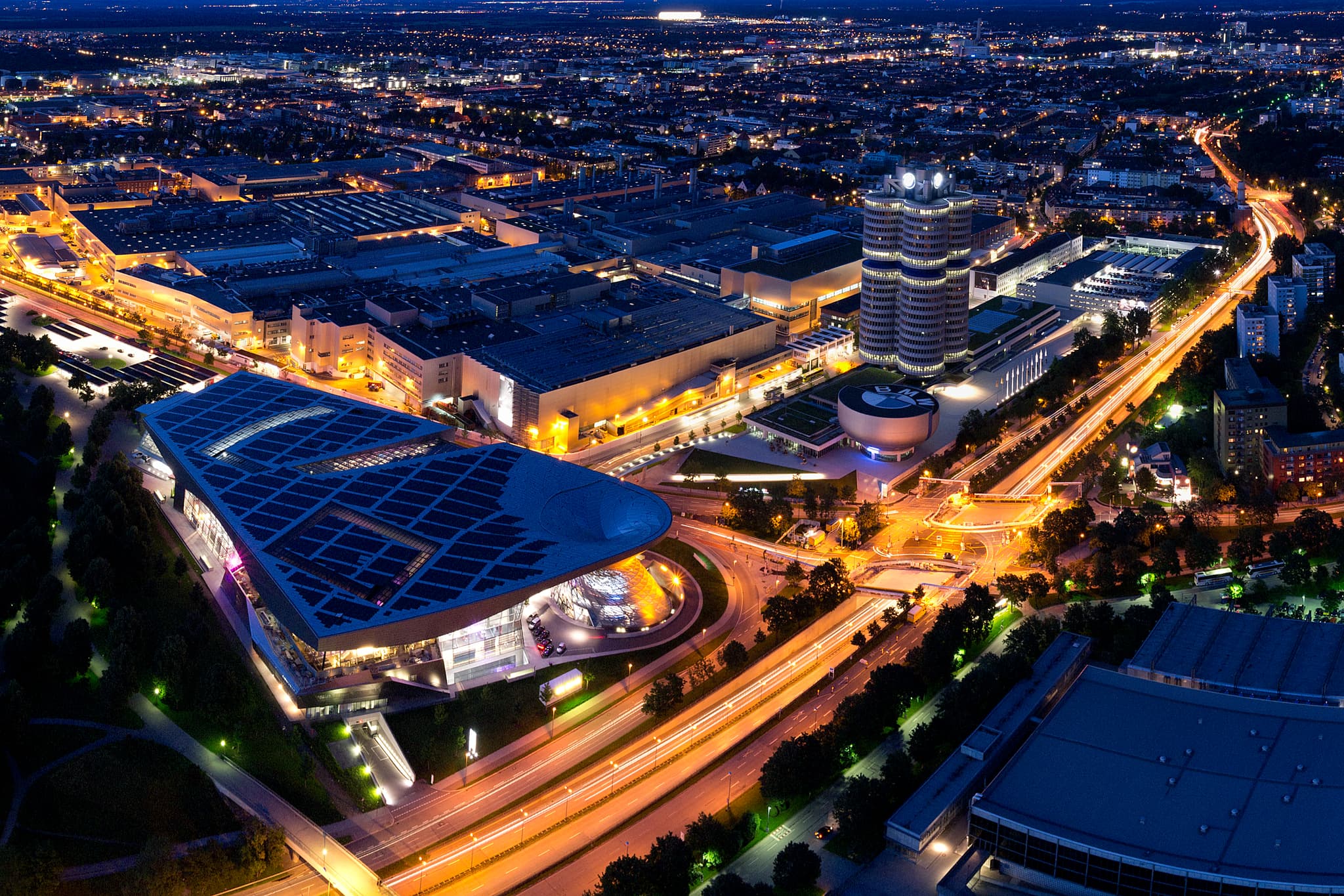 Nächtliche Ansicht vom Fernsehturm in München, Oberbayern, Deutschland. Beleuchtete Kulisse der Stadt mit BMW-Welt und Mittlerer Ring.