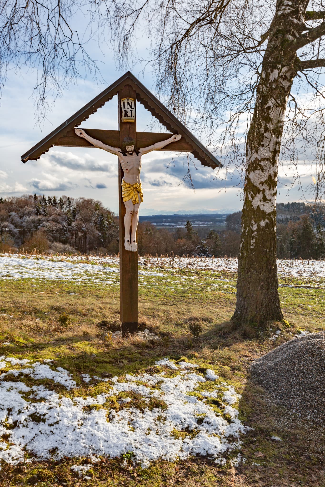 Winterlandschaft mit Kreuz bei Friesing, Gemeinde Reischach, Landkreis Altötting, Oberbayern. Die Szene zeigt ein Motiv der Inn-Salzach Region in Deutschland.