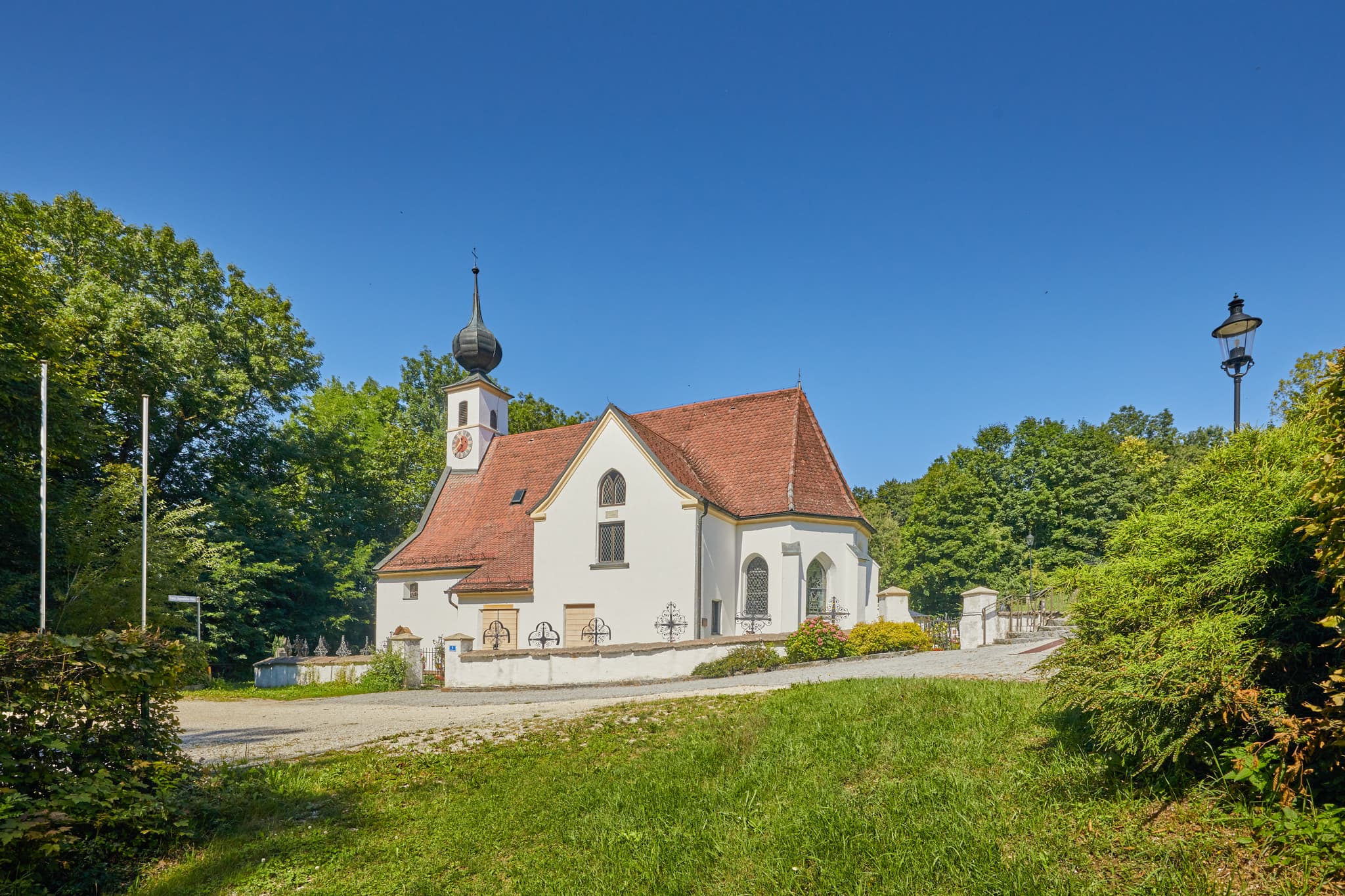 Pfarrkirche Radegundis in Hadermarkt, St. Radegund, Braunau am Inn, Oberösterreich, Innviertel, Österreich. Kirchengebäude in grüner Landschaft.