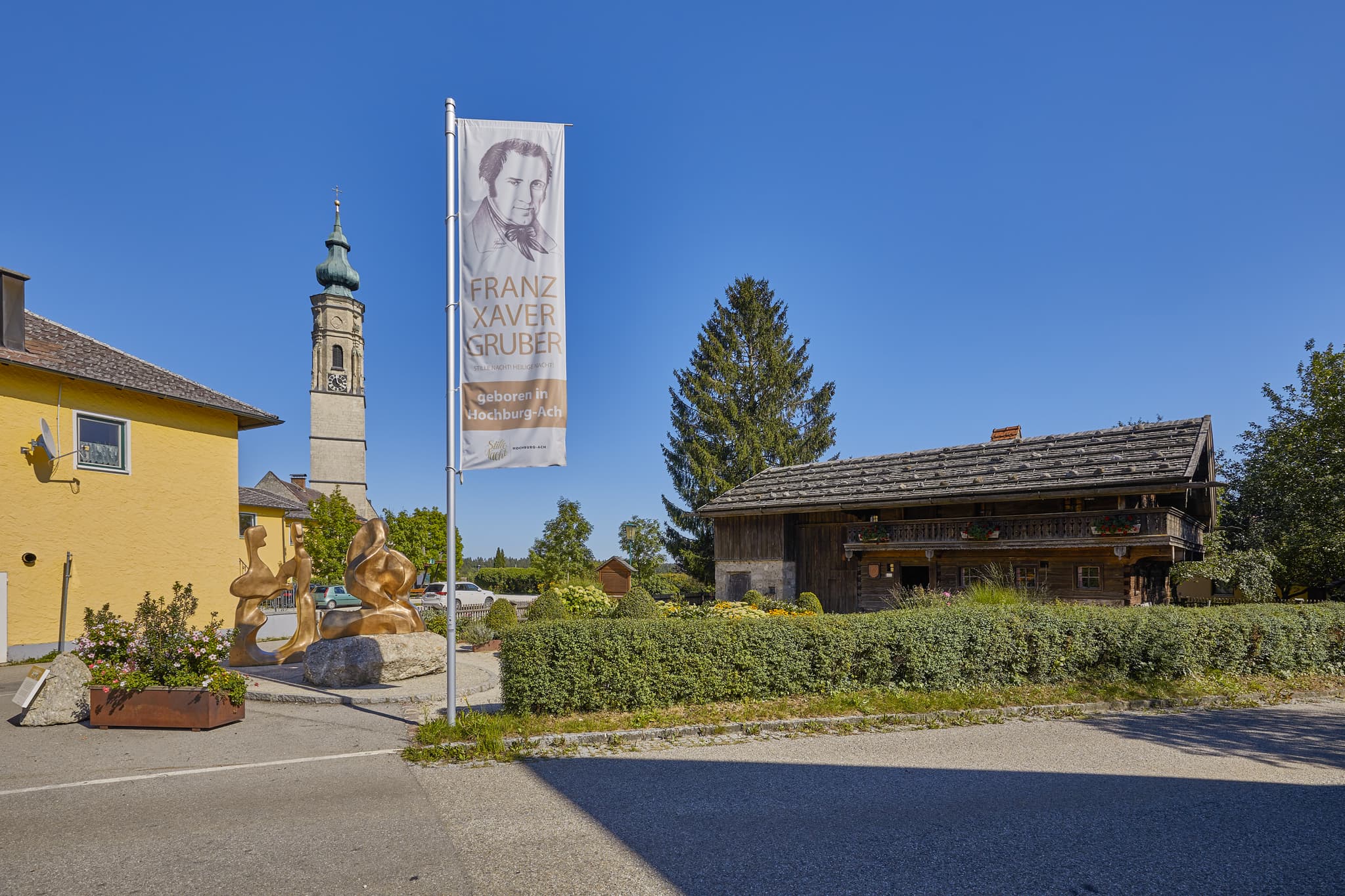 Franz-Xaver-Gruber Haus in Hochburg-Ach, Braunau am Inn, Oberösterreich, Innviertel, Österreich. Zeigt das bekannte Haus mit Turm und Fahne bei klarem Wetter.