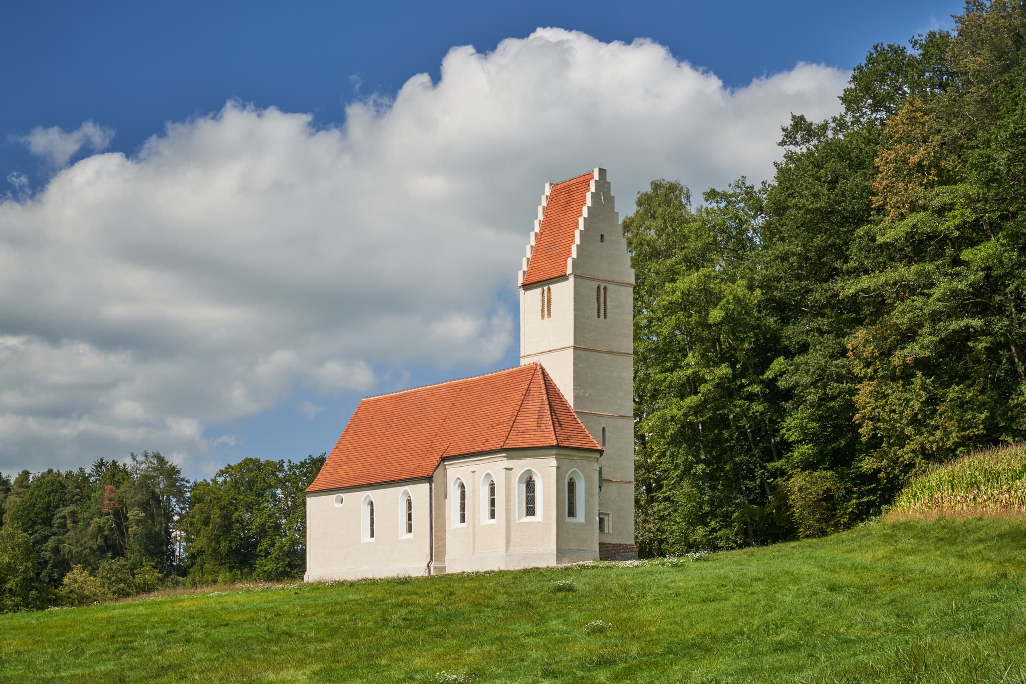 Sigrün Kirche in Pleiskirchen, Landkreis Altötting, Oberbayern, Inn-Salzach, Bayern, Deutschland. Die kleine Landkirche umgeben von Feldern am Wald.