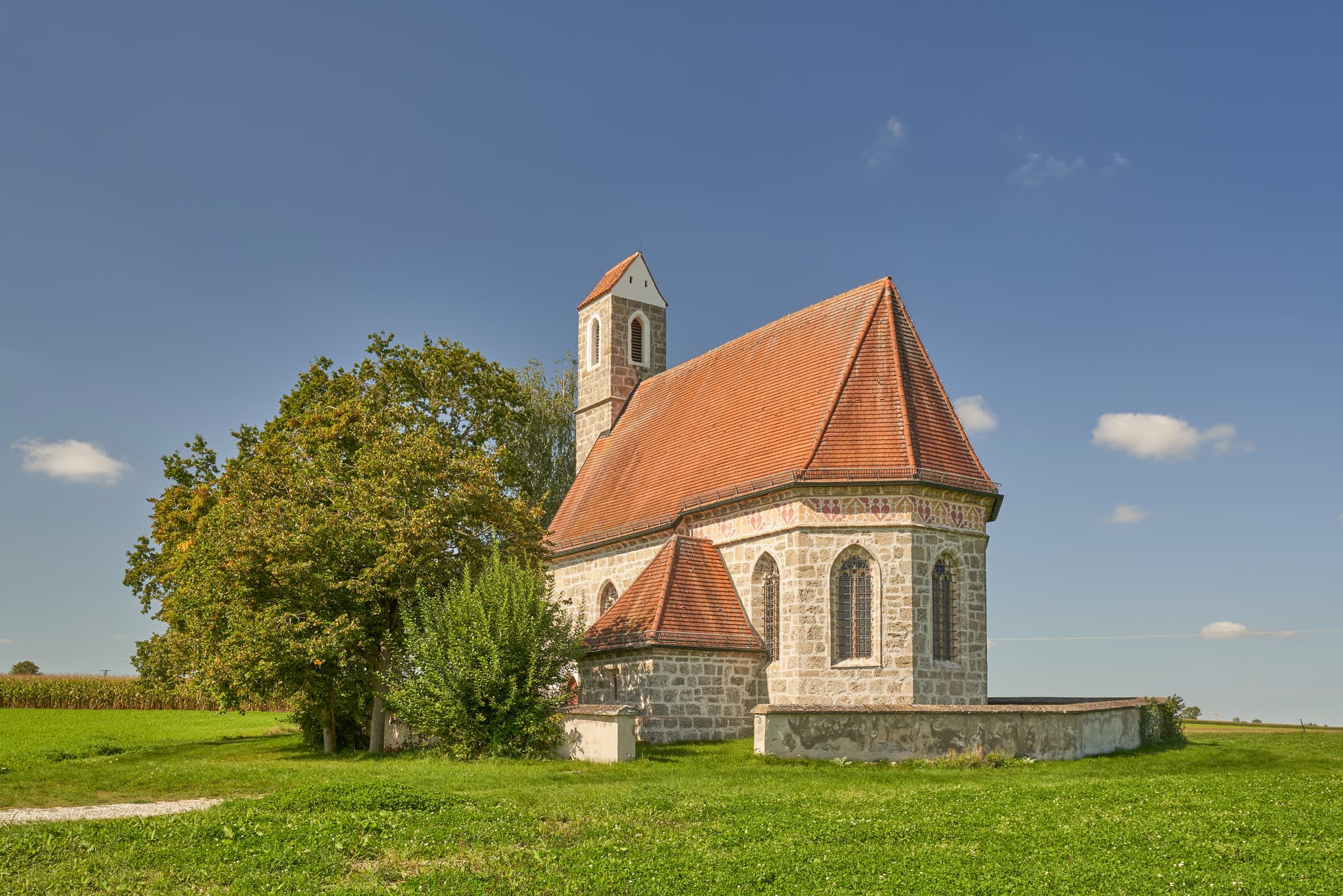 Kirche St. Alban, Peterskirchen, Tacherting, Landkreis Traunstein, Oberbayern. Motiv der Kirche umgeben von Feldern im Chiemgau, Deutschland.