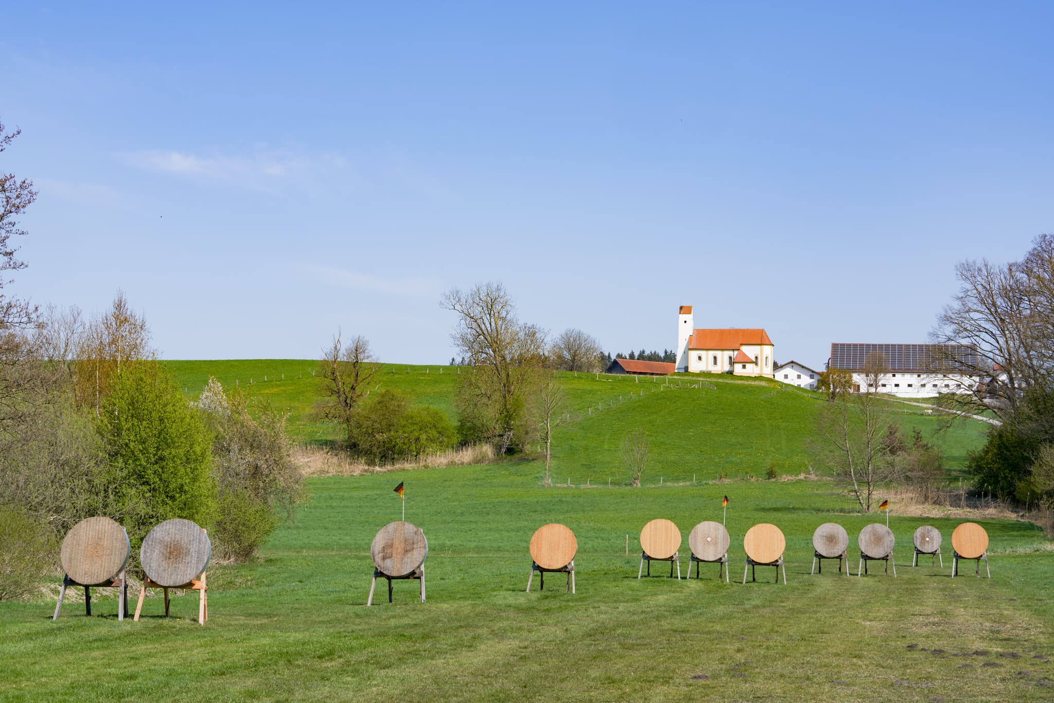 Idyllische Aufnahme von Kirchisen Bogenschützen in Mettenheim. Die Kirche vor der Kulisse des Landkreises Mühldorf am Inn in Oberbayern, Region Inn-Salzach.