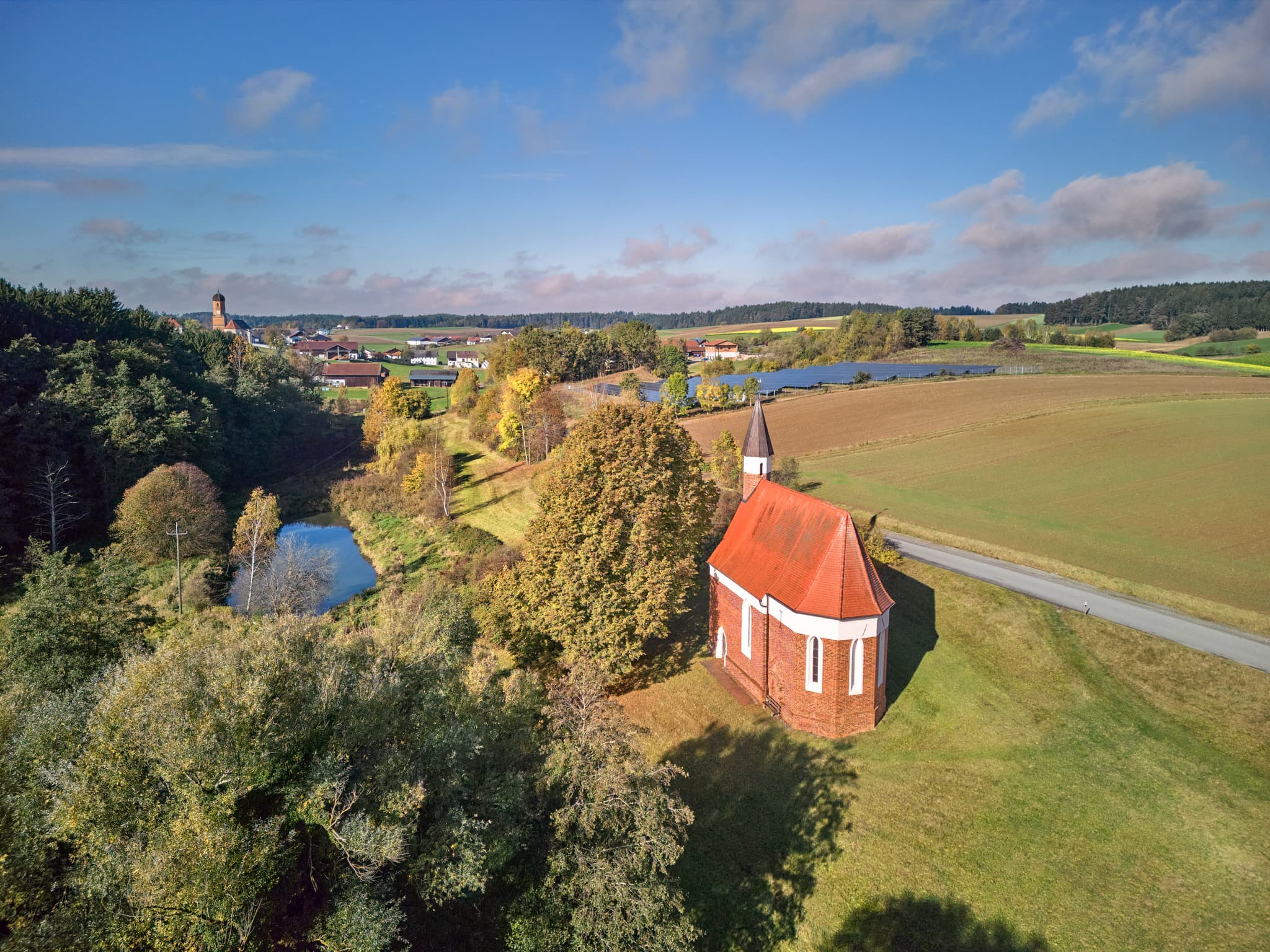 Die St. Koloman Kirchlein in Martinskirchen, Wurmannsquick, Landkreis Rottal-Inn, Niederbayern. Landschaft mit Feldern und Teich im Holzland.