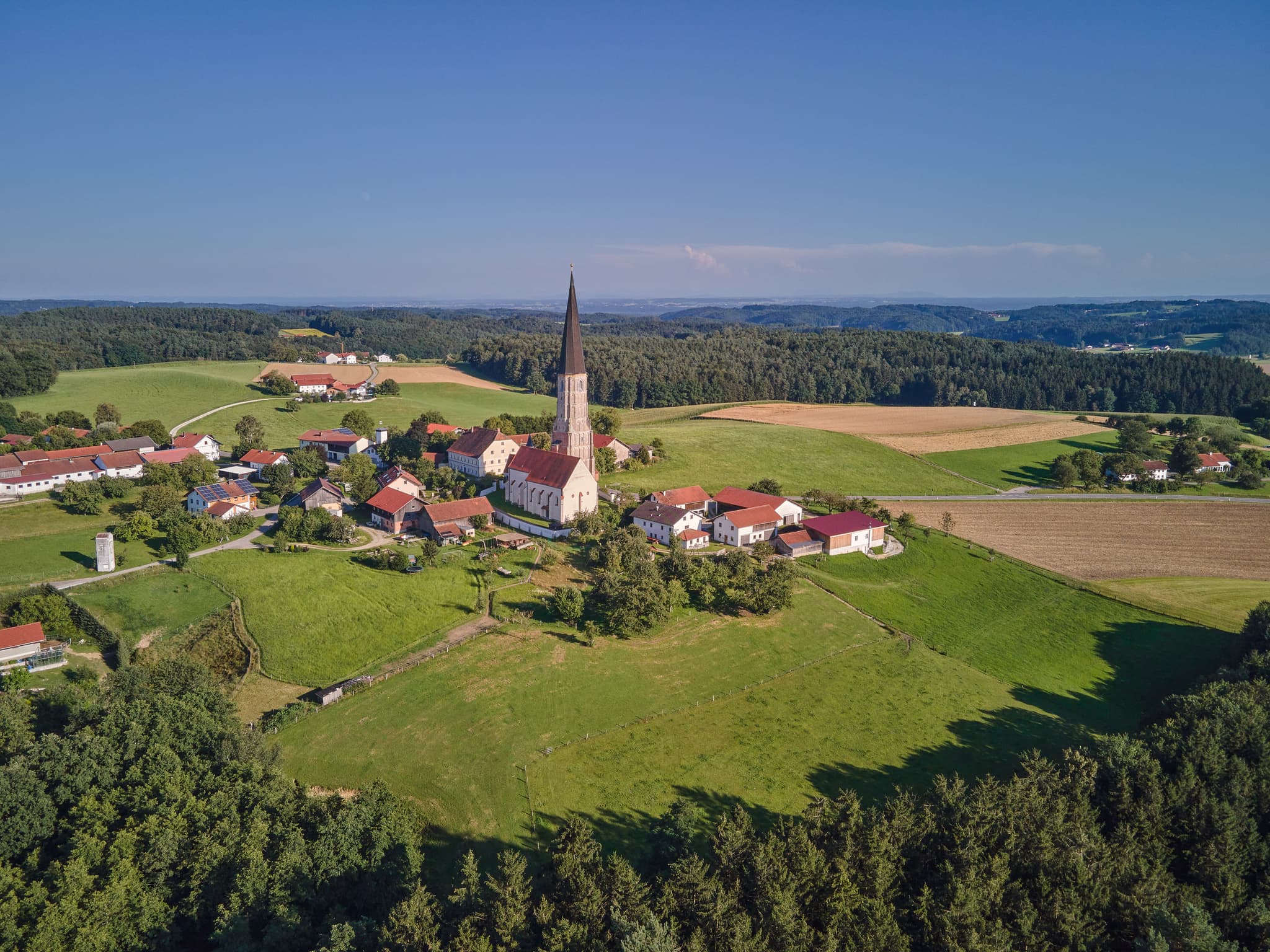 Panoramablick auf Schildthurn, Ortsteil von Zeilarn, im Landkreis Rottal-Inn, Niederbayern. Dorf mit Kirche, Feldern, Wiesen und Wäldern im Holzland.