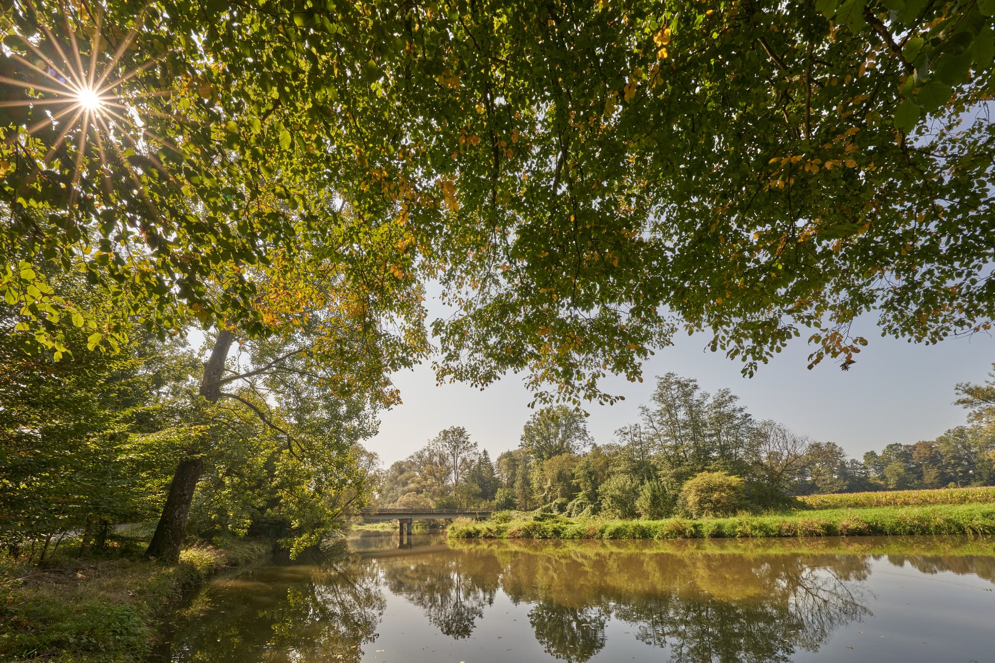 IFlusslandschaft in Aufham Isen, Winhöring, Landkreis Altötting, Oberbayern. Fluss, Brücke und die grüne Vegetation der Inn-Salzach Region.