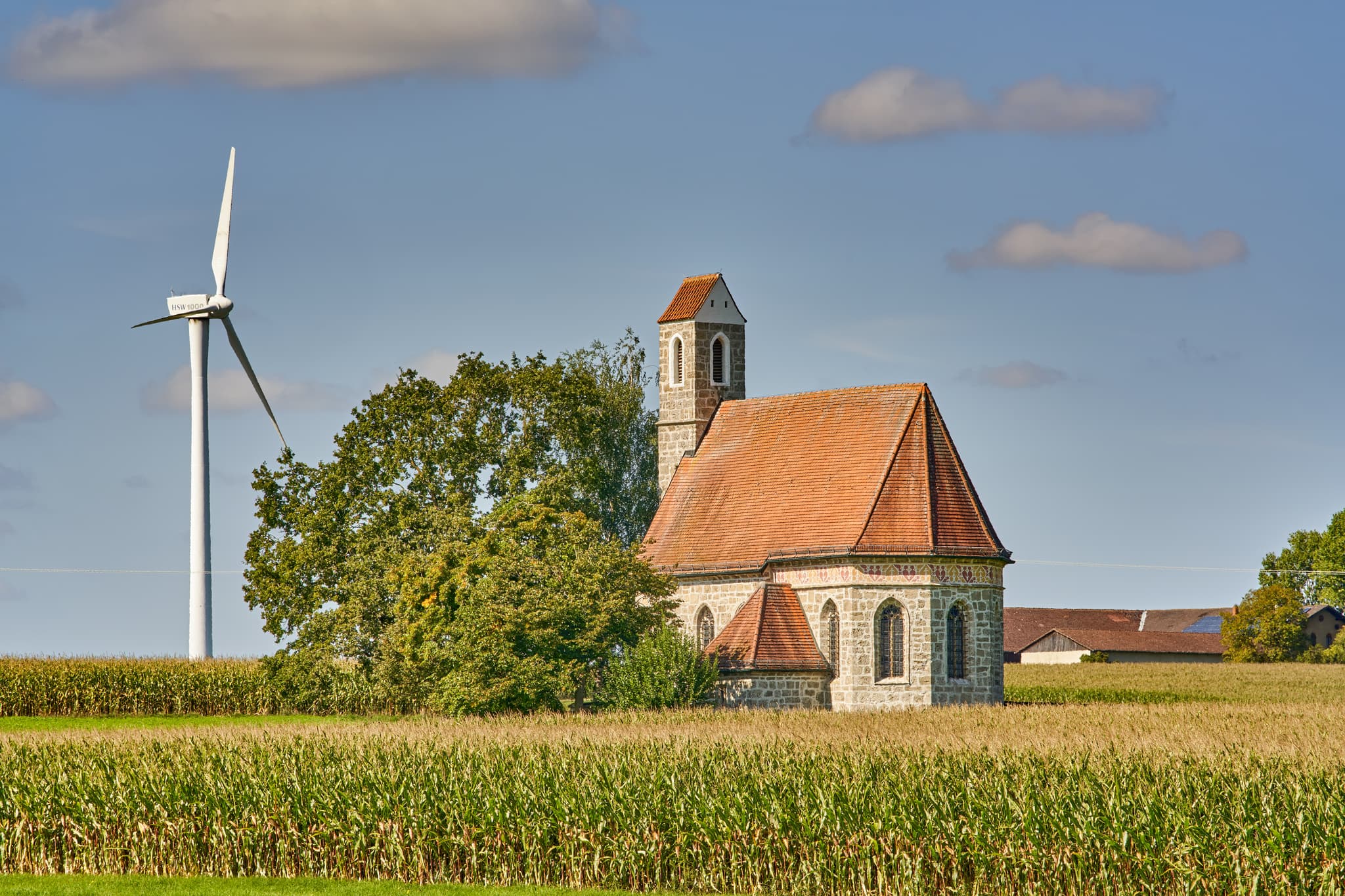 Kirche St. Alban, Peterskirchen, Tacherting, Landkreis Traunstein, Oberbayern. Motiv der Kirche umgeben von Feldern im Chiemgau, Deutschland.