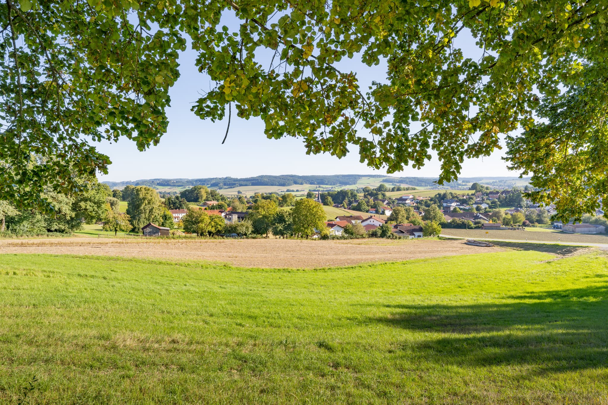 Hirschbach, Bad Birnbach, Rottal-Inn, Niederbayern, Deutschland. Blick auf grüne Felder, Wiesen und den Ort Hirschbach im Holzland. Bruder Konrad Kapelle.