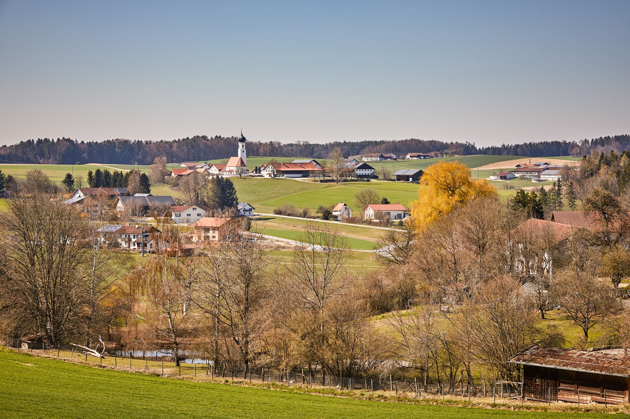 Endlkirchen, Ortsteil von Erlbach, im Landkreis Altötting, Oberbayern. Landschaft mit Kirche, Häusern, Hügeln und Bäumen der Region Inn-Salzach, Deutschland.