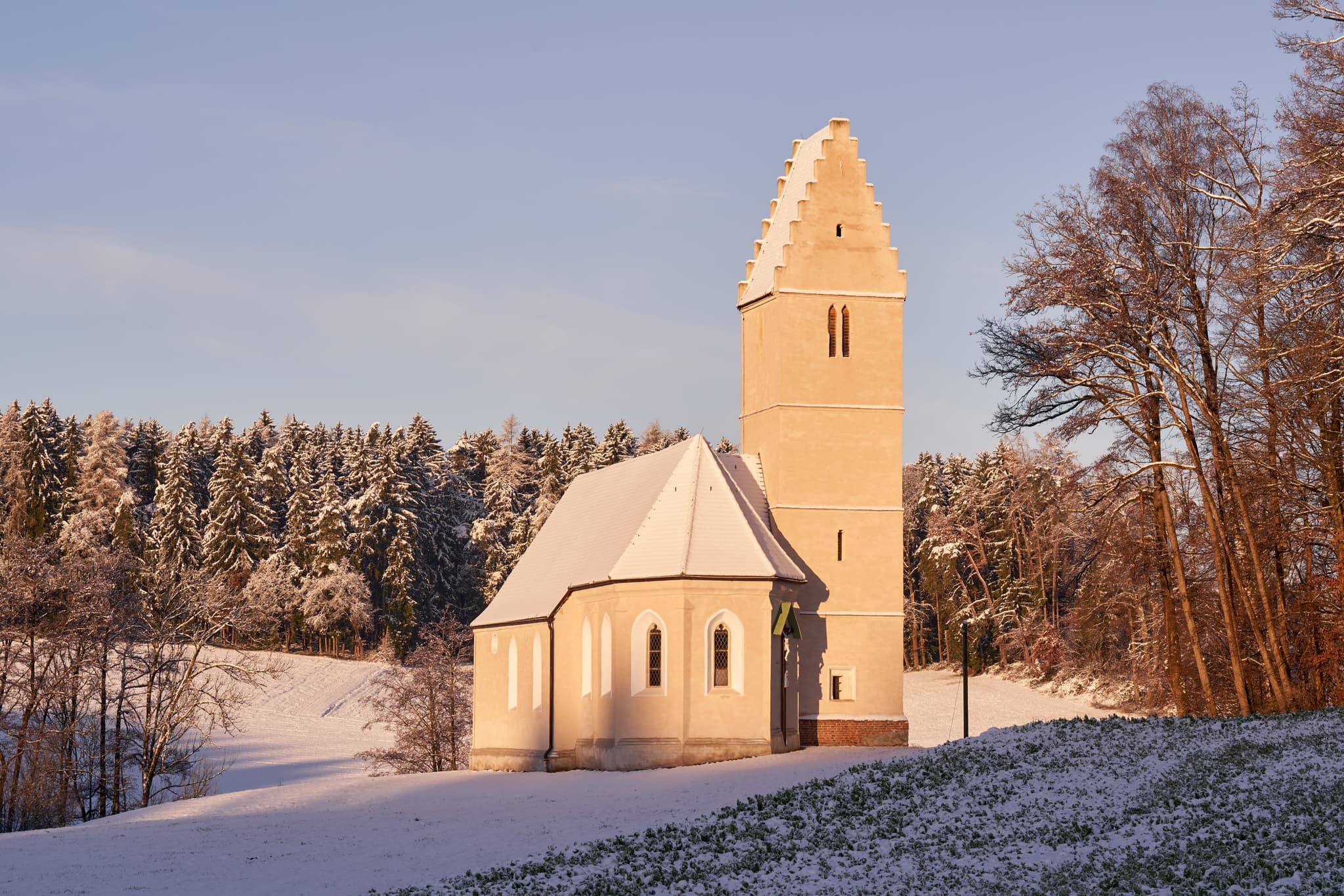 Winterliche Ansicht der Sigrün Kirche in Pleiskirchen, Altötting, Oberbayern, Inn-Salzach, Bayern. Die Kirche steht auf einer schneebedeckten Anhöhe.