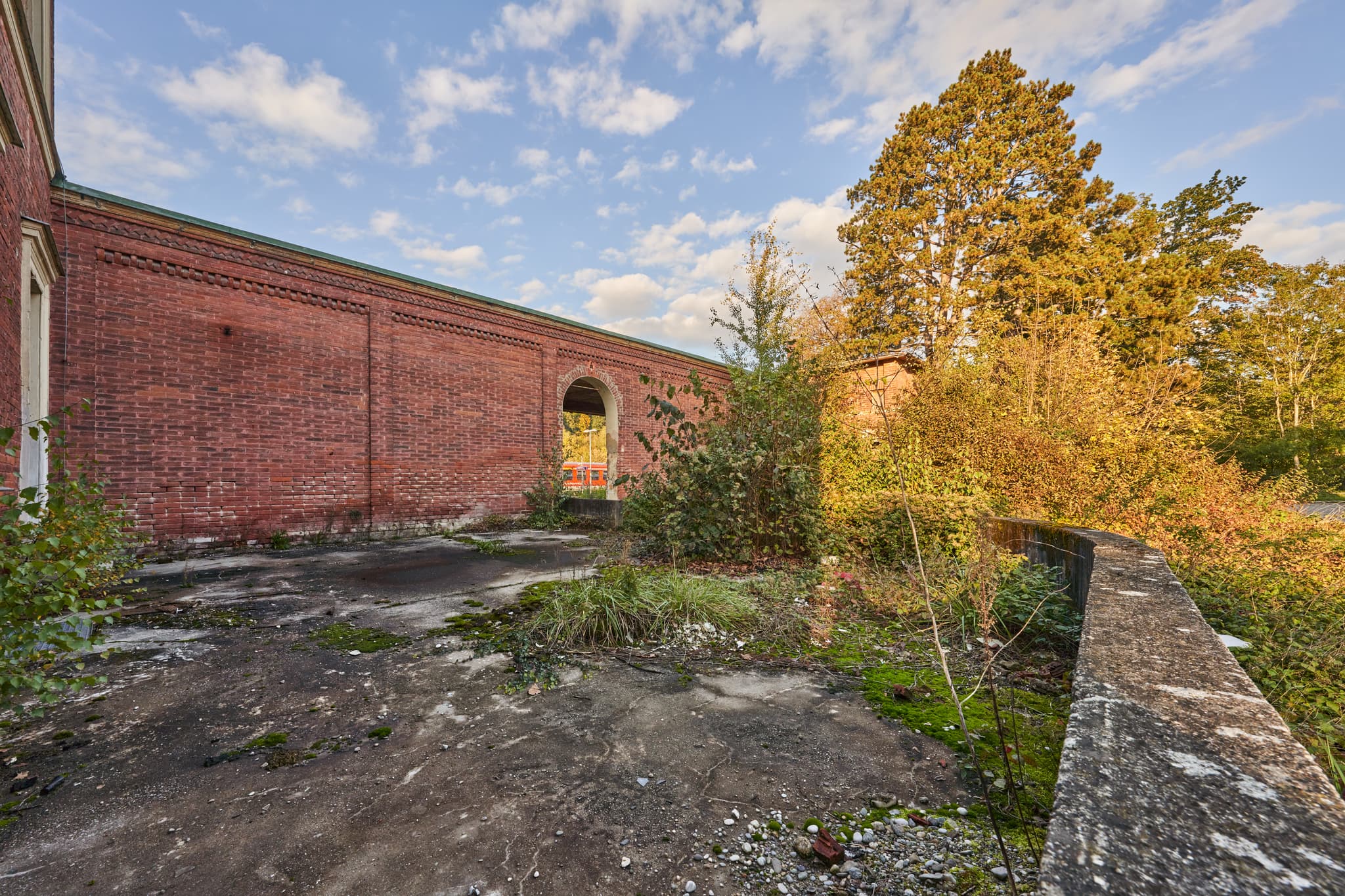 Eisenfelden Bahnhof Neuötting, Winhöring, Altötting, Oberbayern. Eine Backsteinmauer und zugewachsene Plattform am Bahnhof, Inn-Salzach Region.