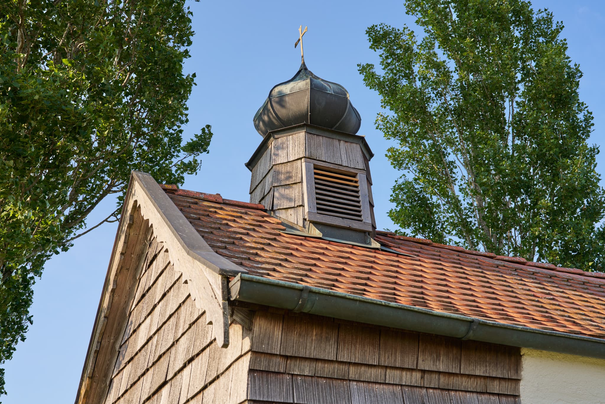 Die historische Zell St. Koloman-Kapelle in Ortenburg, Lkr. Passau, Deutschland, ein Kleinod der Donau-Wald Region in Niederbayern, unter blauem Himmel.