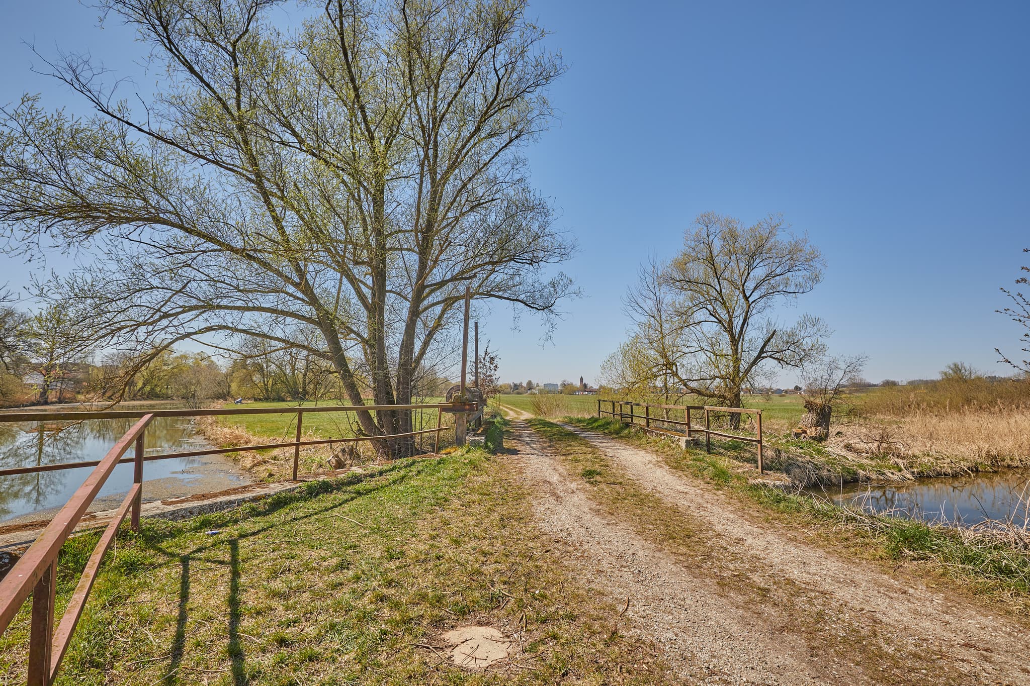 Ländlicher Weg mit Brücke über Rott Seitenarm, Unterdietfurt, Rottal-Inn, Niederbayern. Die Szenerie zeigt die Landschaft des Holzlandes in Deutschland.