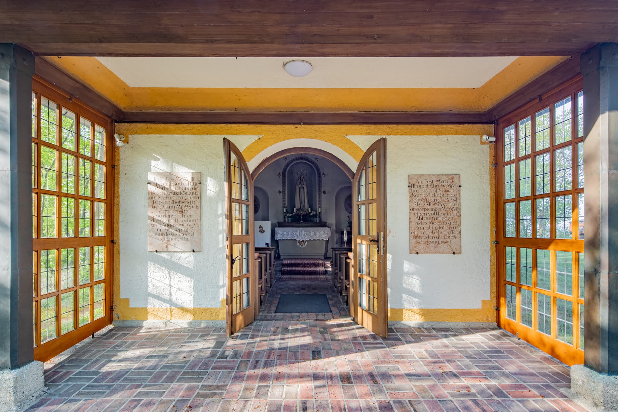 Hirten Kapell,e Margarethenberg in Burgkirchen, Altötting. Kapelle Oberbayern, Inn-Salzach, Deutschland. Überdachter Eingang mit Holztüren, Ziegelfliesenboden.