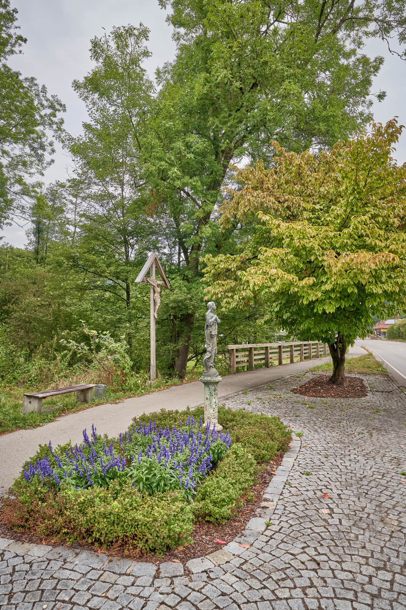 Wegkreuz mit Marienstatue und Blumenbeet bei Brandmühle, Reischach, Landkreis Altötting, Oberbayern, Region Inn-Salzach in Deutschland.