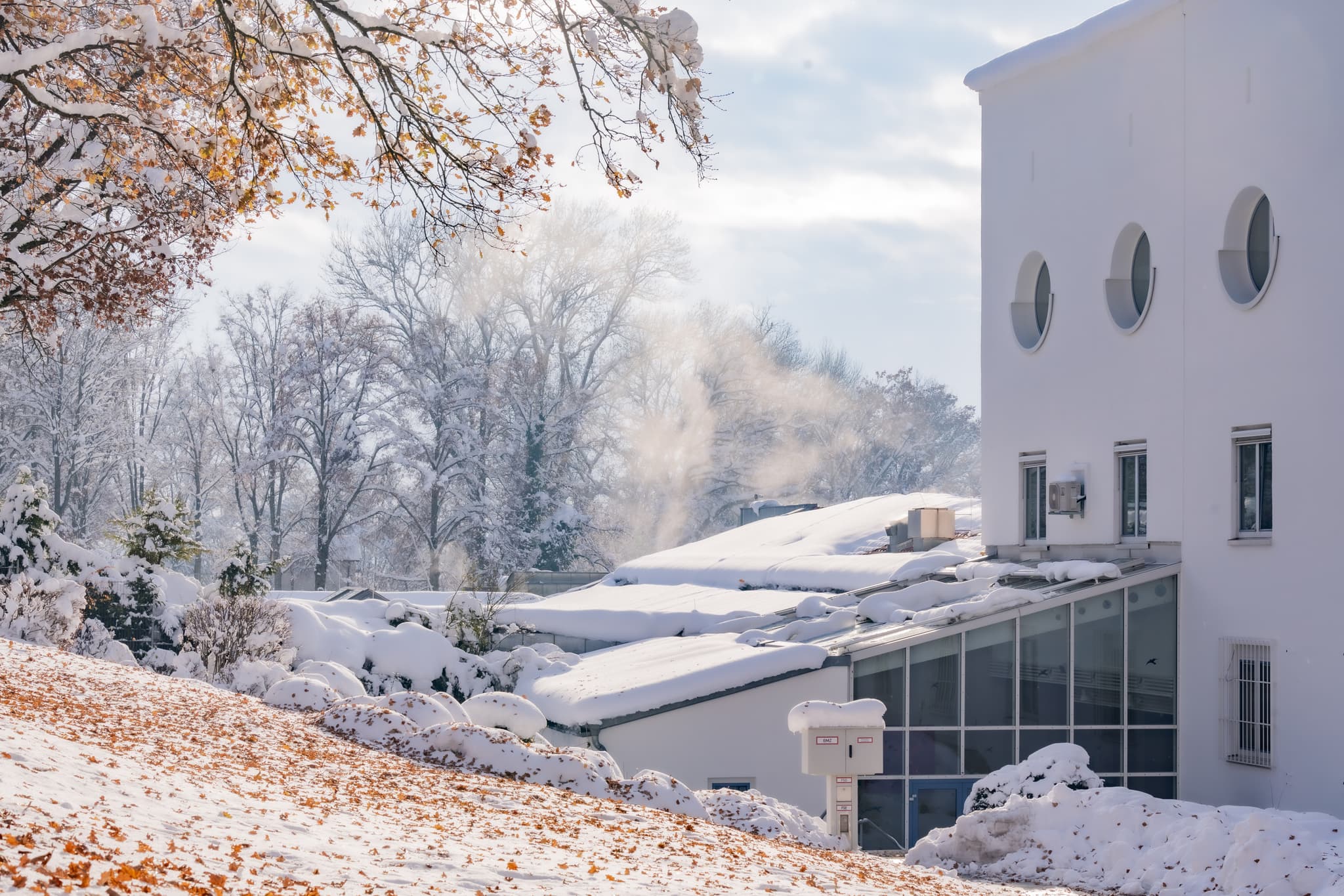 Winterliche Ansicht der Therme in Bad Griesbach, Passau, Niederbayern. Das Bild zeigt das Außenbecken im Schnee, umgebende Gebäuden und verschneiter Landschaft.