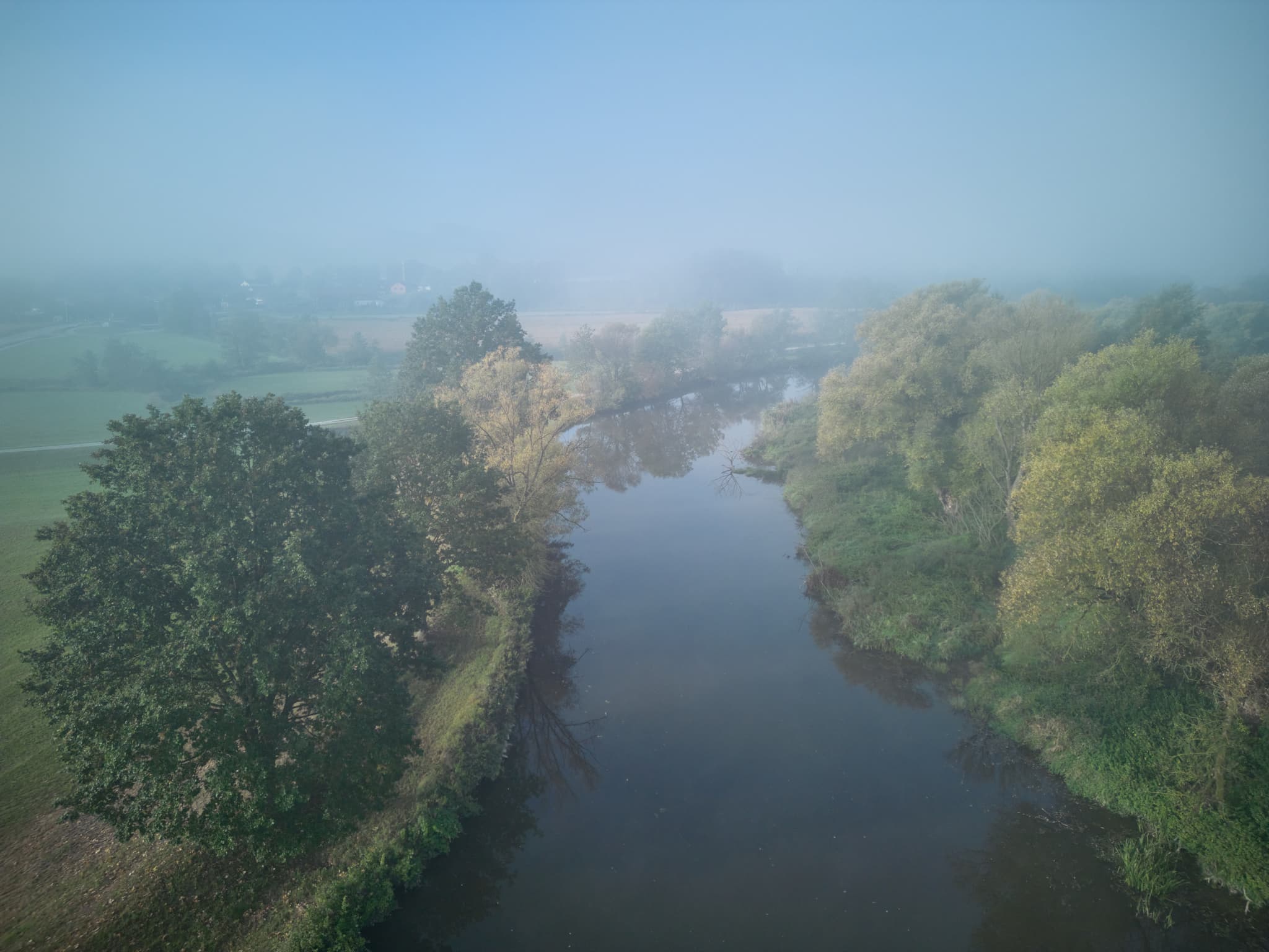 Der Fluss Rott, umgeben von herbstlichen Bäumen, im Nebel bei Bad Birnbach. Die Landschaft im Landkreis Rottal-Inn, Niederbayern, Region Bäderdrieck.