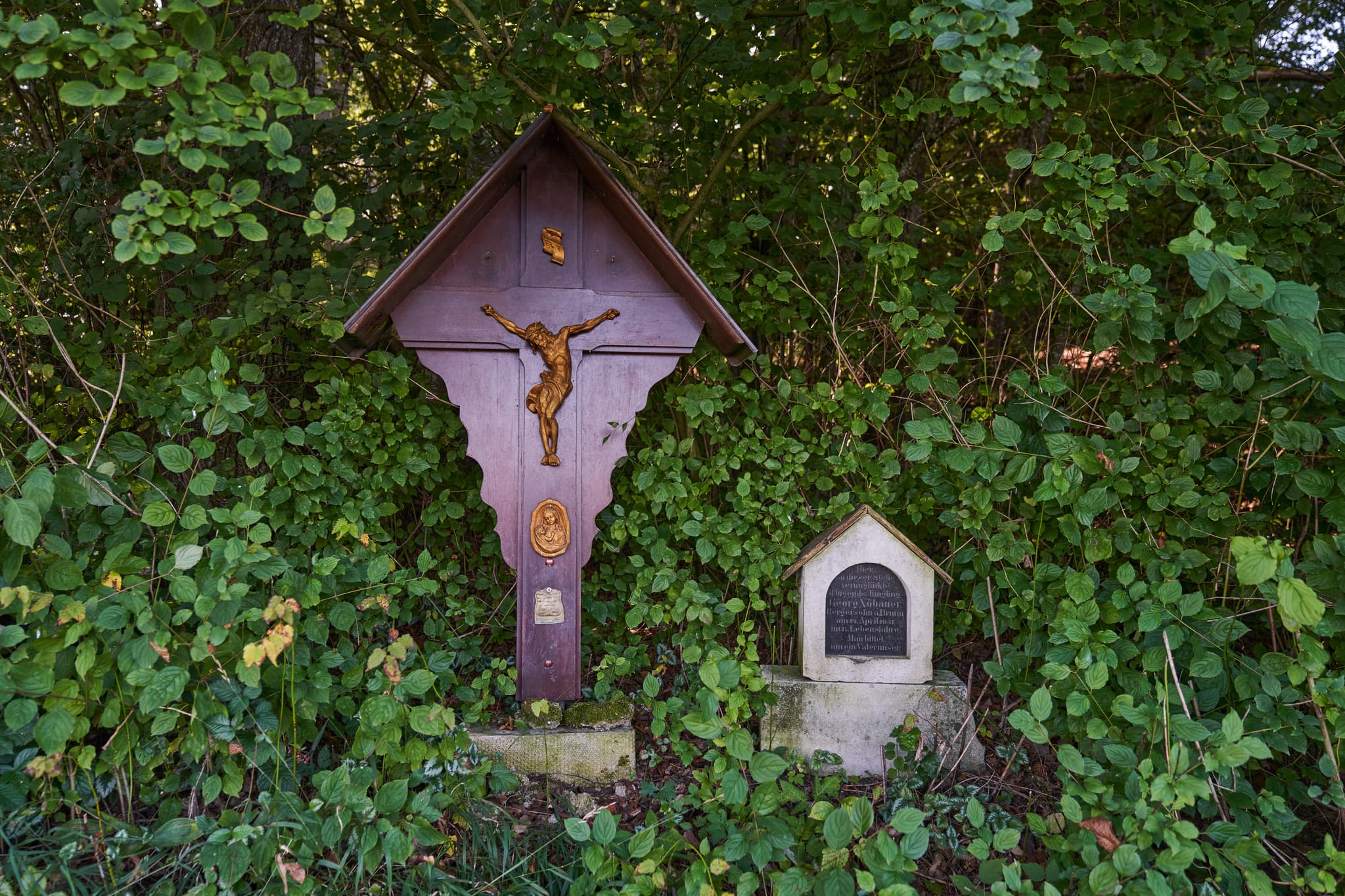 Wegkreuz mit Kruzifix und Marterl am St.-Rupert-Pilgerweg in Kastl, Altötting, Oberbayern. Dieses Denkmal liegt in der Inn-Salzach-Region, mgeben von Natur.