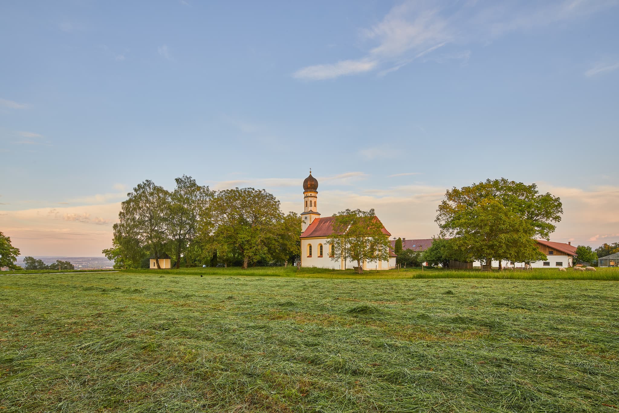 Bildstock und Kirche mit Baum in Winterberg, Gars am Inn. Ländliche Landschaft im Landkreis Mühldorf am Inn, Oberbayern, Region Inn-Salzach, Deutschland.