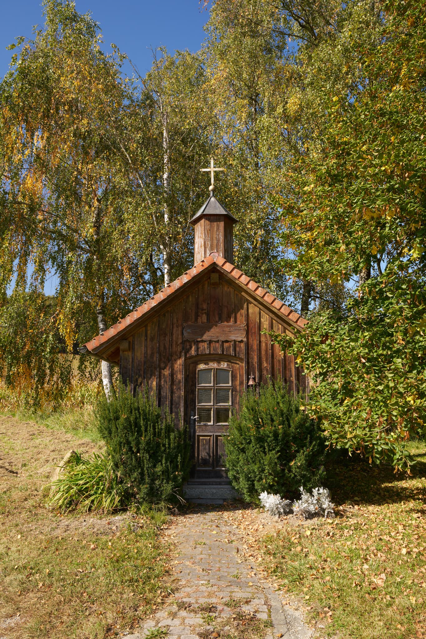 Kleine Holzkapelle Stadlreith Kapelle nahe Tettenweis, Landkreis Passau, Niederbayern. Umgeben von Herbstbäumen im Bayerischen Wald, Deutschland.