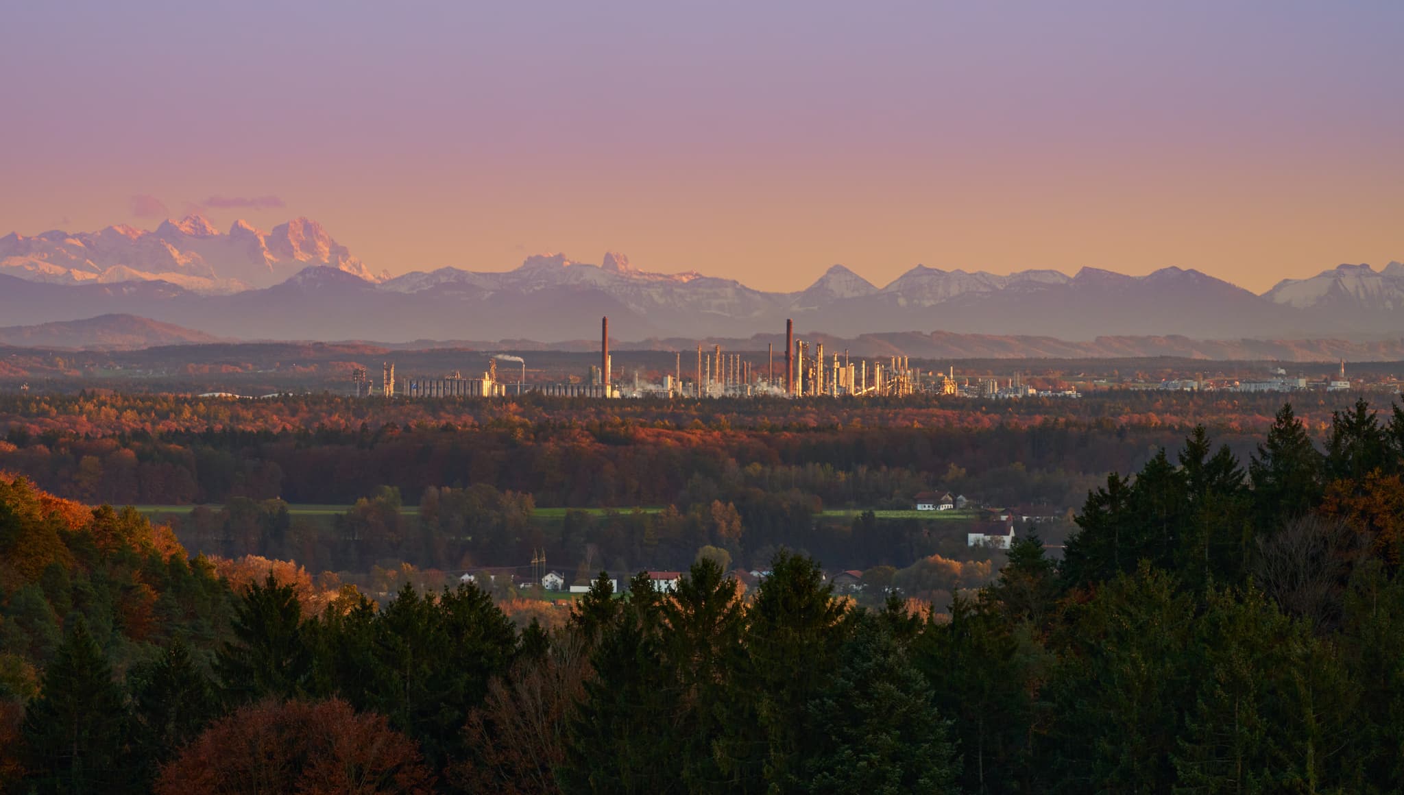 Panoramablick vom Pfaffenberg auf Industrielandschaft bei Erlbach, Landkreis Altötting, Oberbayern. Werk mit Wald und Alpen am Horizont der Region Inn-Salzach.