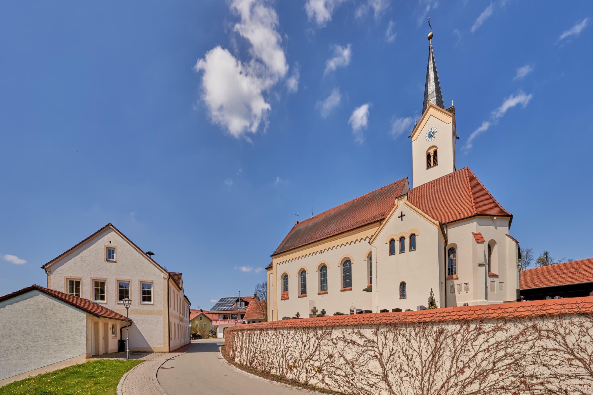 Die Pfarrkirche St. Peter und Paul in Erlbach im Landkreis Altötting, Oberbayern, Deutschland, Region Inn-Salzach und prägt die Ortschaft.