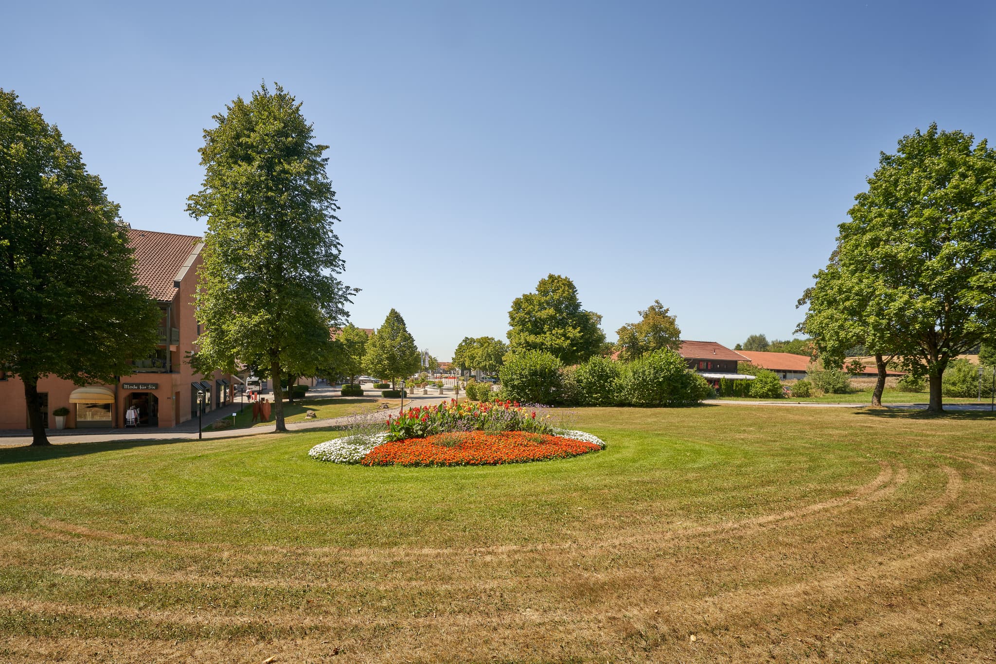 Der Kurpark in Bad Griesbach, Landkreis Passau, Niederbayern, im Bäderdreieck, Deutschland. Einladende Blumeninsel und grüne Anlagen prägen das Bild.