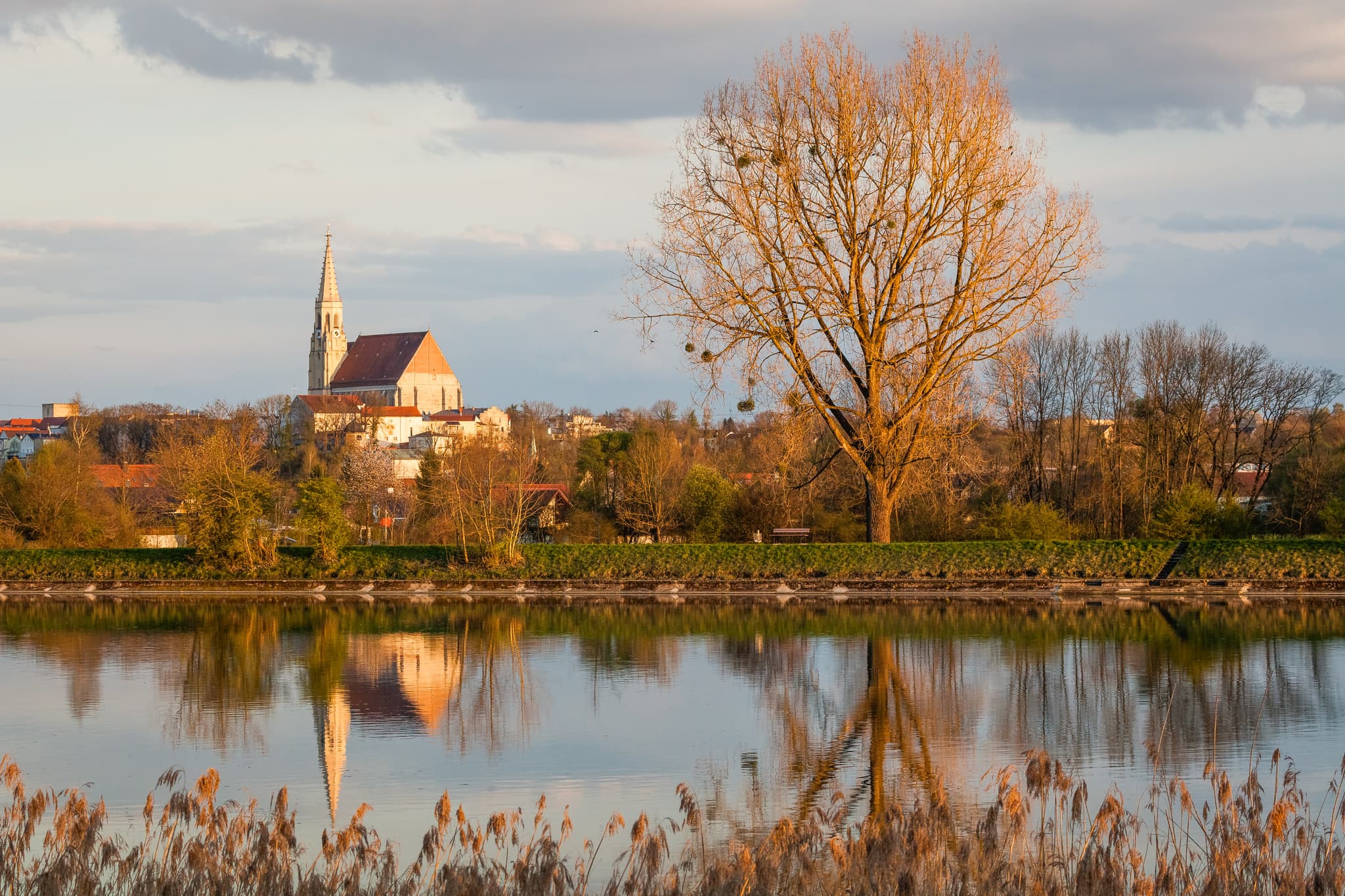 Abendlicher Inn mit Kirche in Neuötting, Landkreis Altötting, Oberbayern. Malerische Landschaft der Inn-Salzach Region in Deutschland.