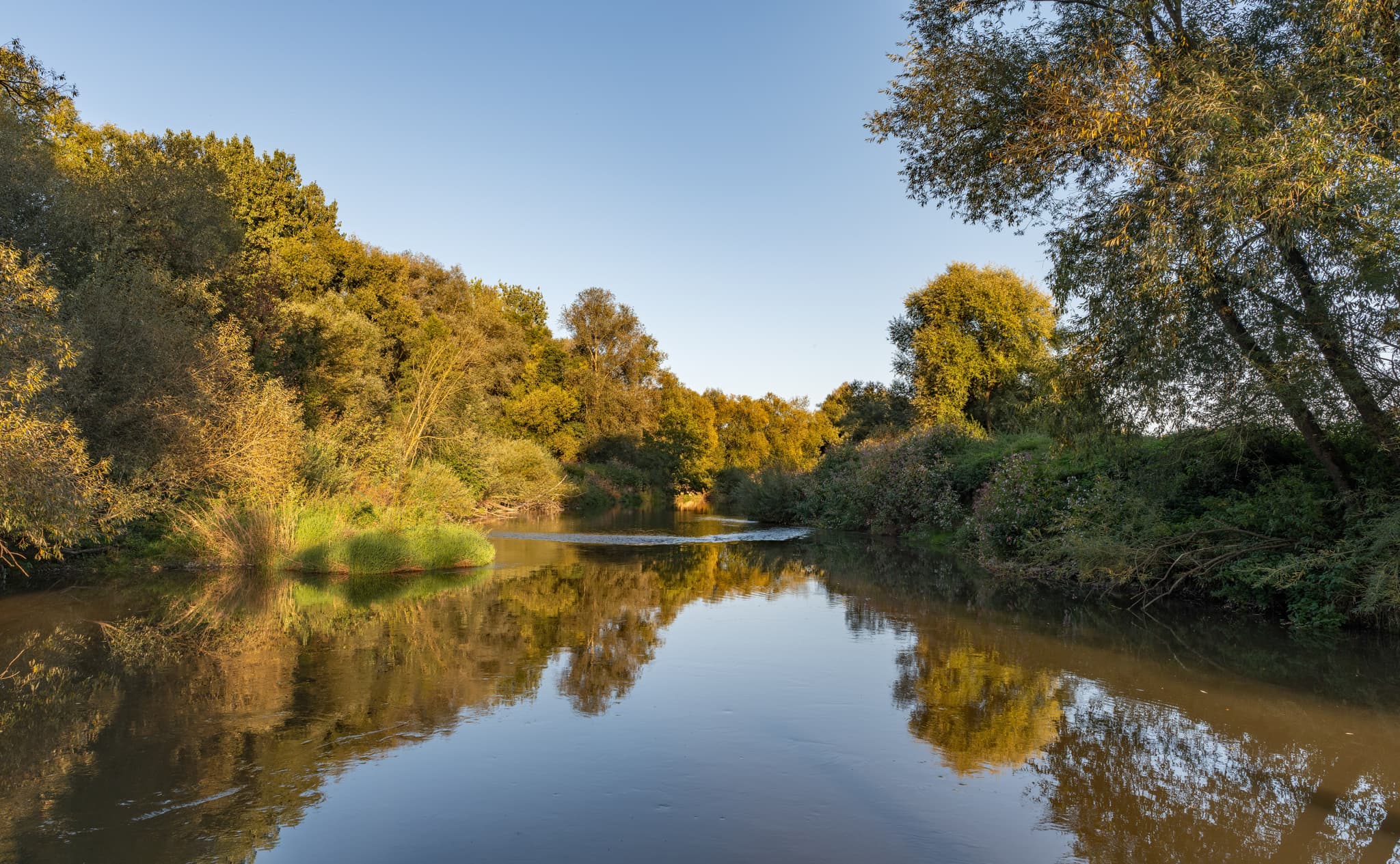 Flusslandschaft der Rott am Golfplatz Postmünster, Deutschland. Ruhiges Gewässer, grüne Ufer. Landkreis Rottal-Inn, Niederbayern, Region Bäderdreieck.