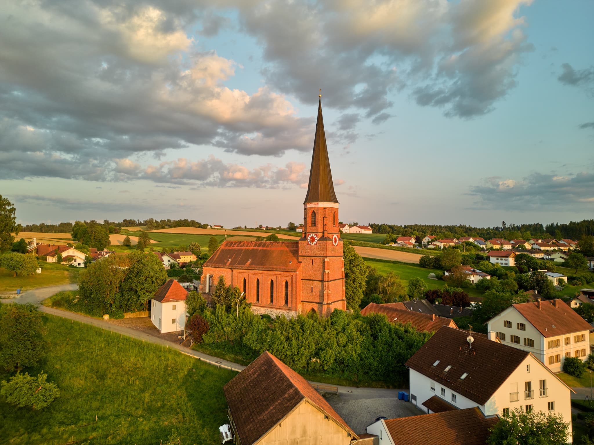 Pfarrkirche St. Rupert in Hirschhorn, Wurmannsquick, Rottal-Inn, Niederbayern. Ländliche Szenerie im Holzland, Deutschland, mit Feldern und Häusern.