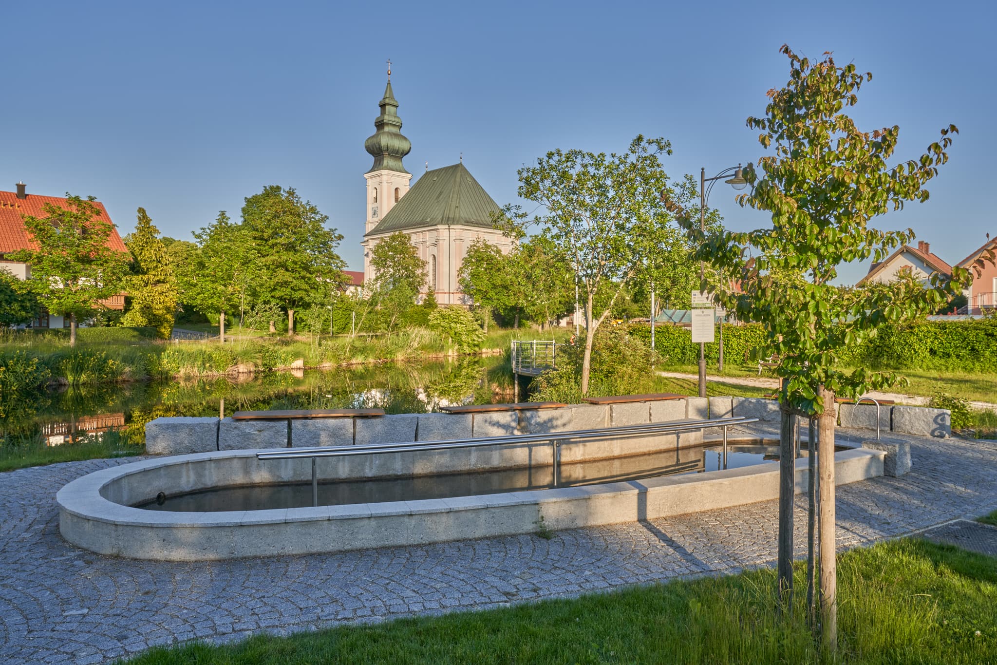 Besuchen Sie die malerische Kneippanlage am Dorfweiher in Kirchweidach, Oberbayern (Inn-Salzach, Bayern, Deutschland). Entspannen Sie an der idyllischen Kirche.