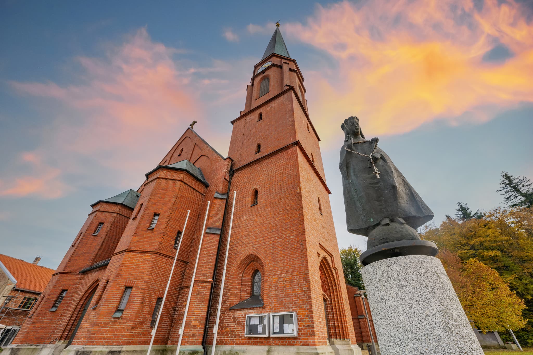 Kirche St. Stephanus  in Schönau, Rottal-Inn, Niederbayern, Deutschland. Motiv ist eine markante rote Backsteinkirche mit hohem Turm in der Region Holzland.