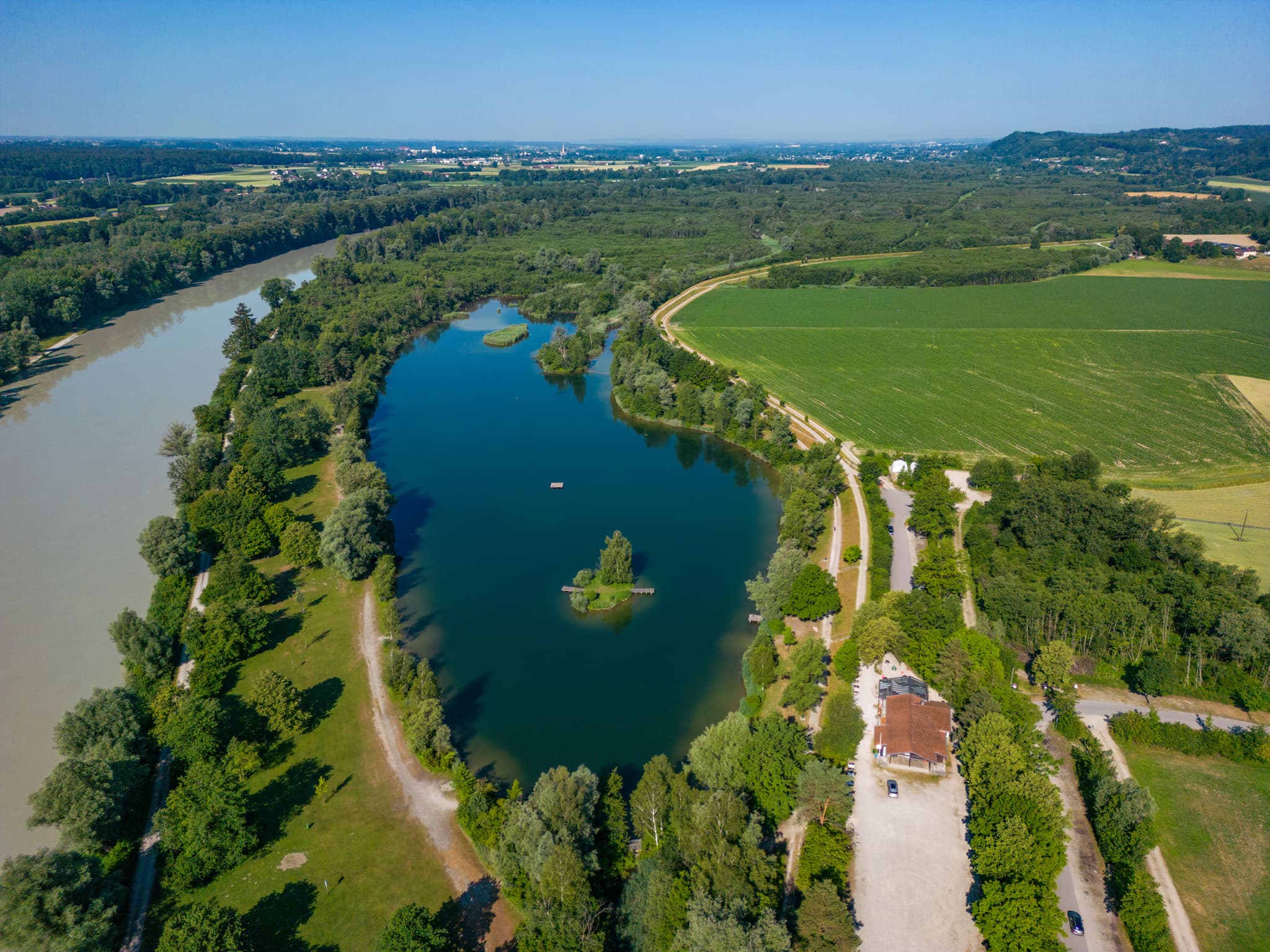 Atemberaubendes Luftbild vom Peracher Badesee in Perach, Oberbayern, Inn-Salzach, Deutschland. Ein idyllischer See inmitten grüner Landschaft.