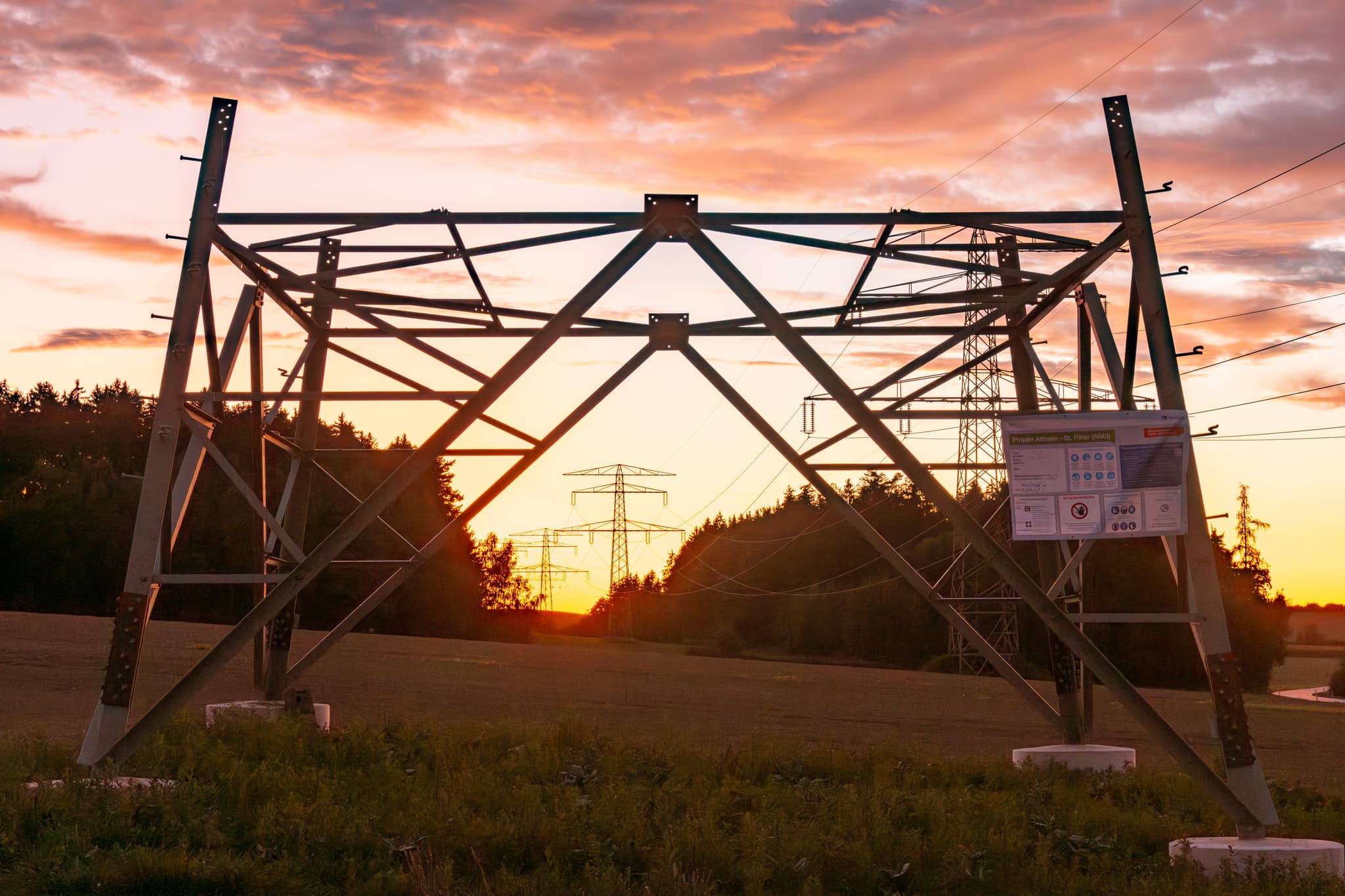 Stromtrasse Altheim - St. Peter bei Sonnenuntergang in Frauenhaselbach, Neumarkt St. Veit, Mühldorf am Inn, Oberbayern, Deutschland.