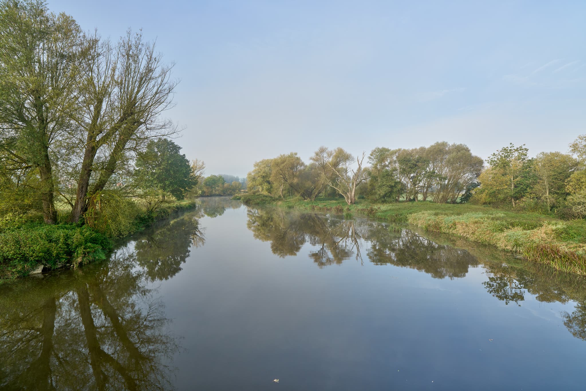 Die Rott fließt ruhig durch herbstliche Landschaft mit Uferbäumen und Spiegelungen in Bad Birnbach, Landkreis Rottal-Inn, Niederbayern, im Bäderdrieck.