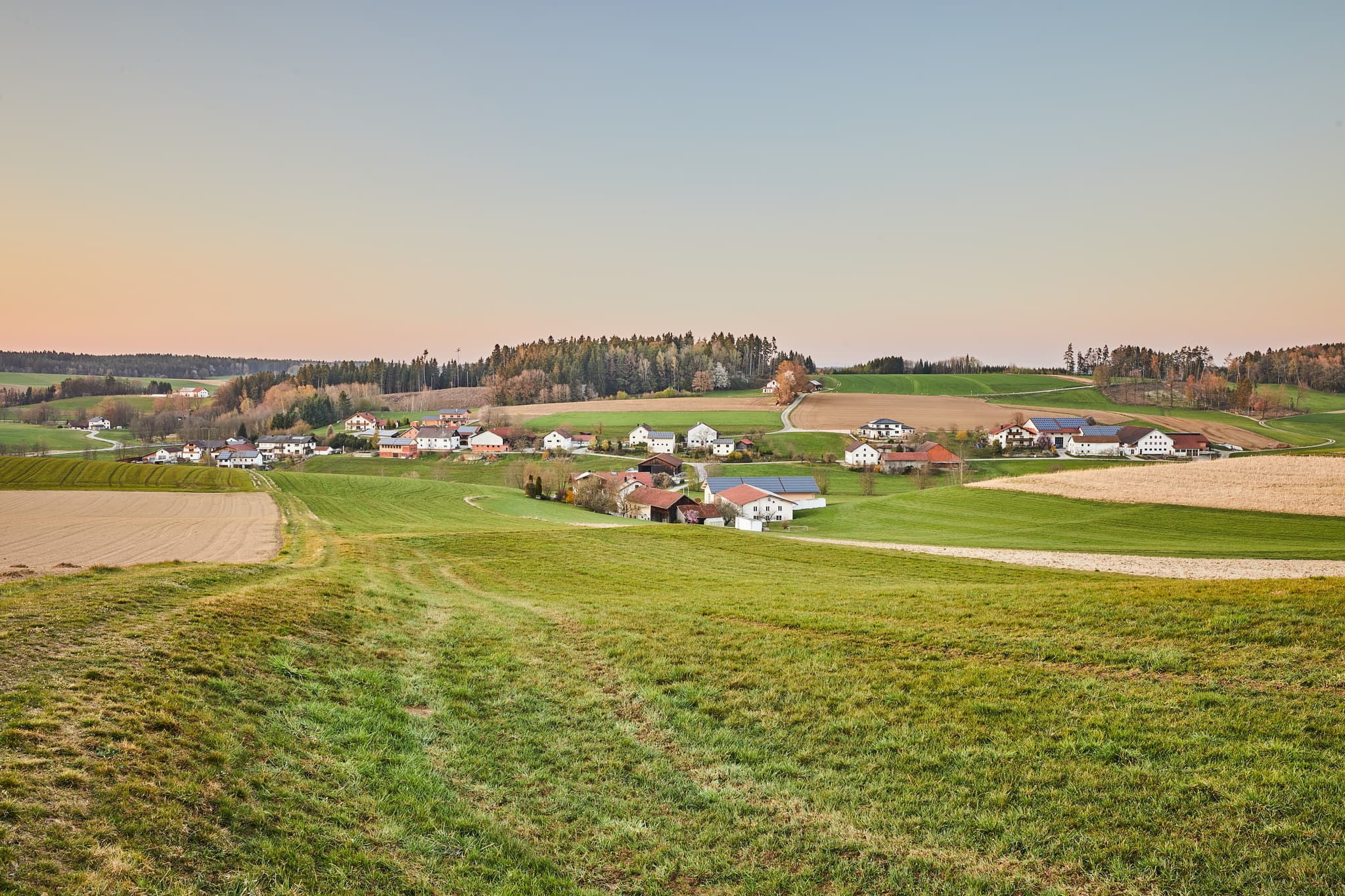 Landschaft mit Feldern und Häusern in Arbing, Reischach, Landkreis Altötting, Oberbayern, Deutschland. Typische Szenerie der Inn-Salzach-Region.