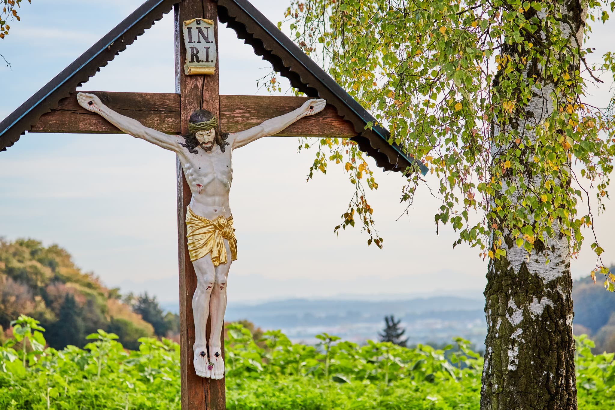 Wegkreuz in Unterfriesing, Reischach, Altötting. Malerische Inn-Salzach-Landschaft, Oberbayern, Deutschland. Typisch bäuerliche Darstellung.