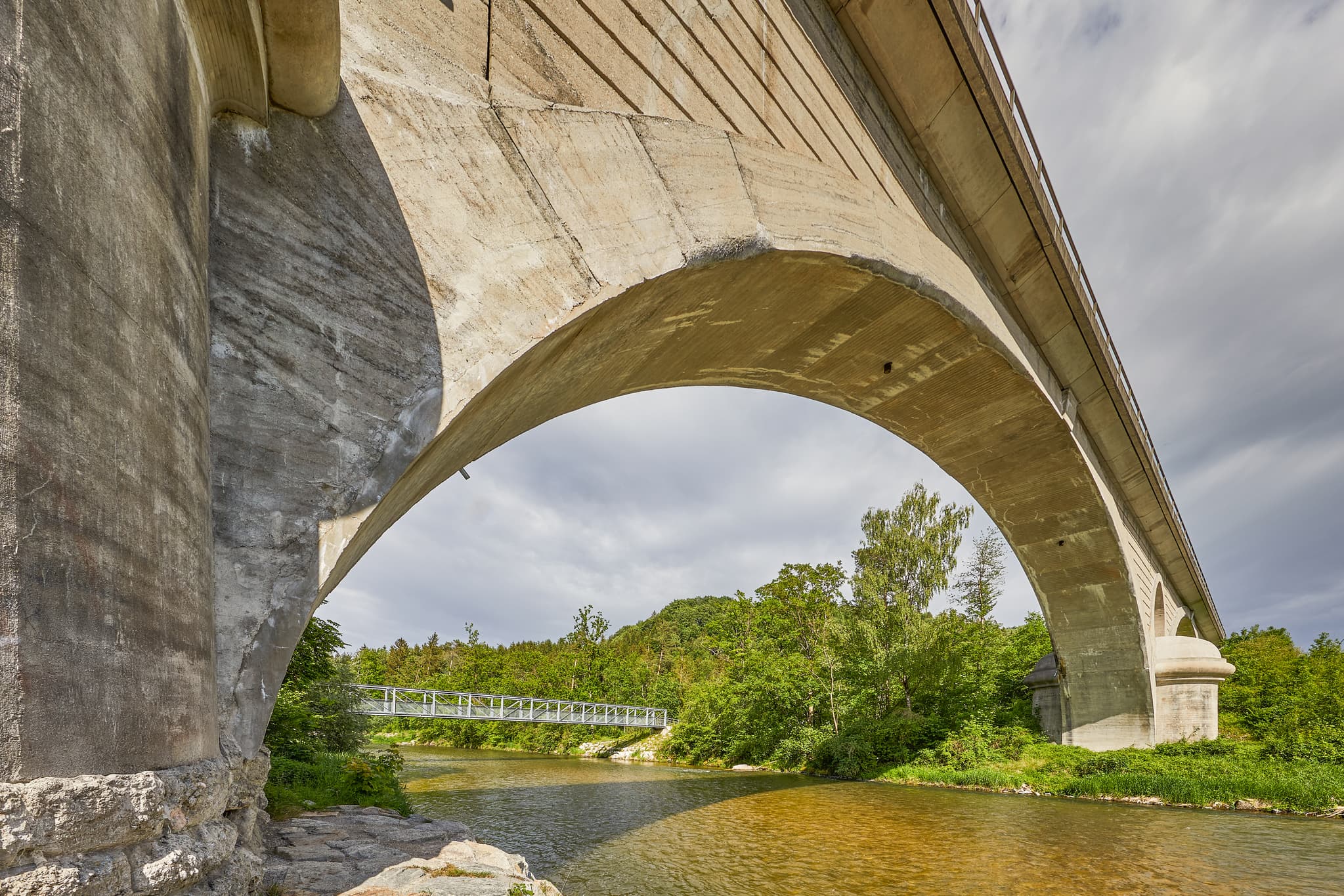 Die imposante Eisenbahnbrücke aus Beton überspannt die Alz in Garching, Altötting. Eine malerische Landschaft in Oberbayern, Region Inn-Salzach, Deutschland.